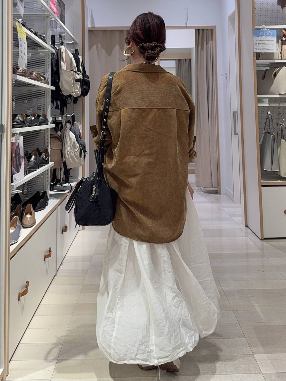 イエロー系のシャツ/ブラウス、ベージュ系のスカート、ブラック系のボストンバッグを着用したレディースの秋コーディネートの8枚目の写真