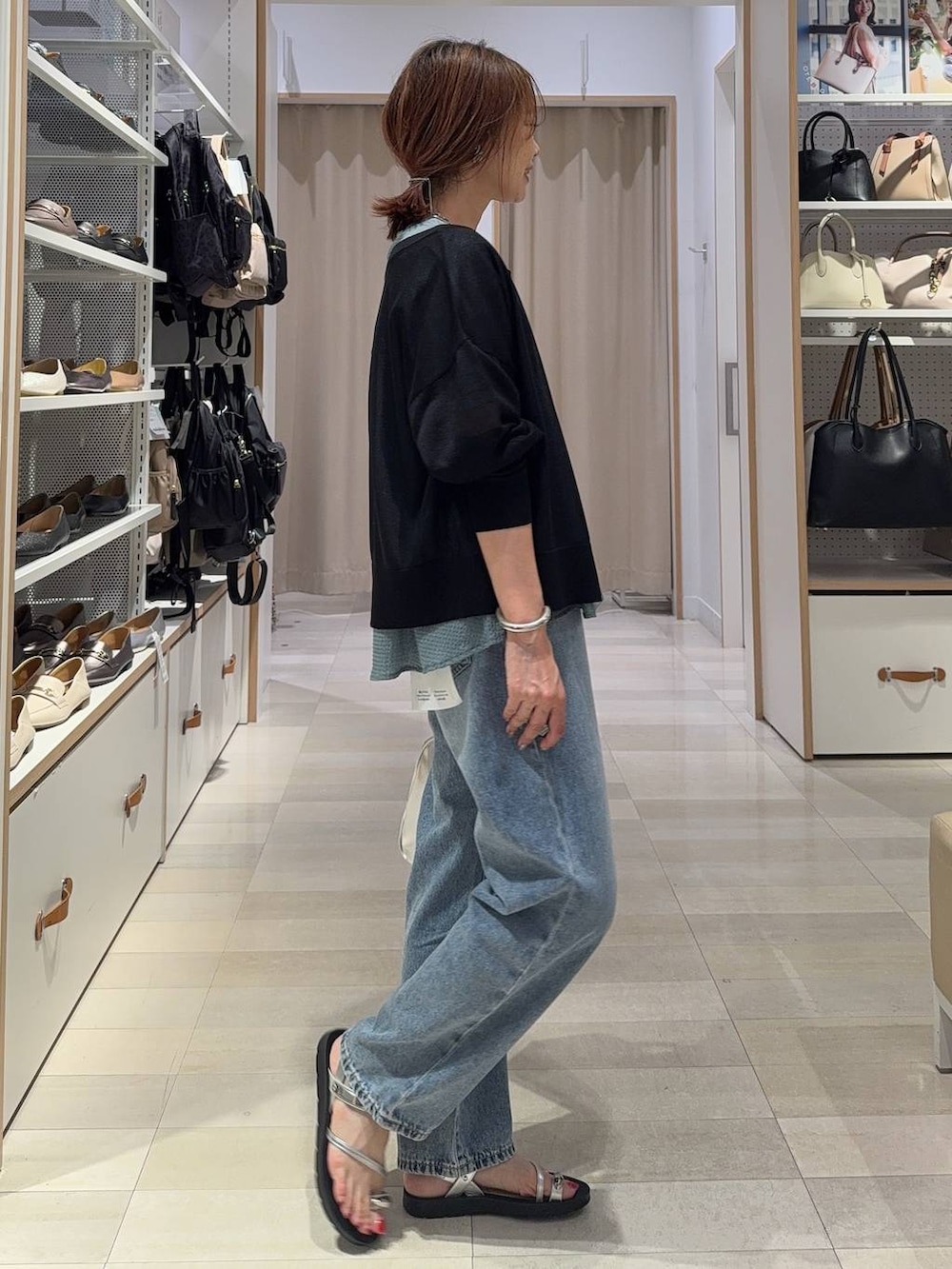 ブルー系のデニムパンツ、グレー系のボストンバッグ、ブラック系のカーディガン/ボレロを着用したレディースの夏コーディネートの6枚目の写真