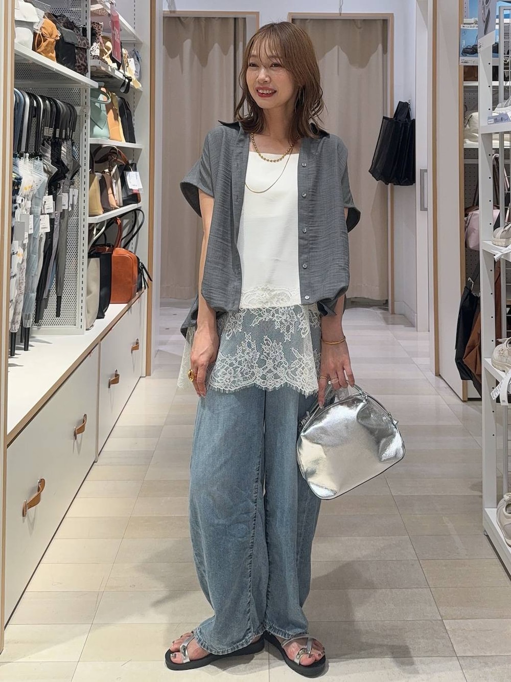 ブラック系のタンクトップ、ベージュ系のパンプス、ブラック系のトートバッグを着用したレディースの夏コーディネートの2枚目の写真
