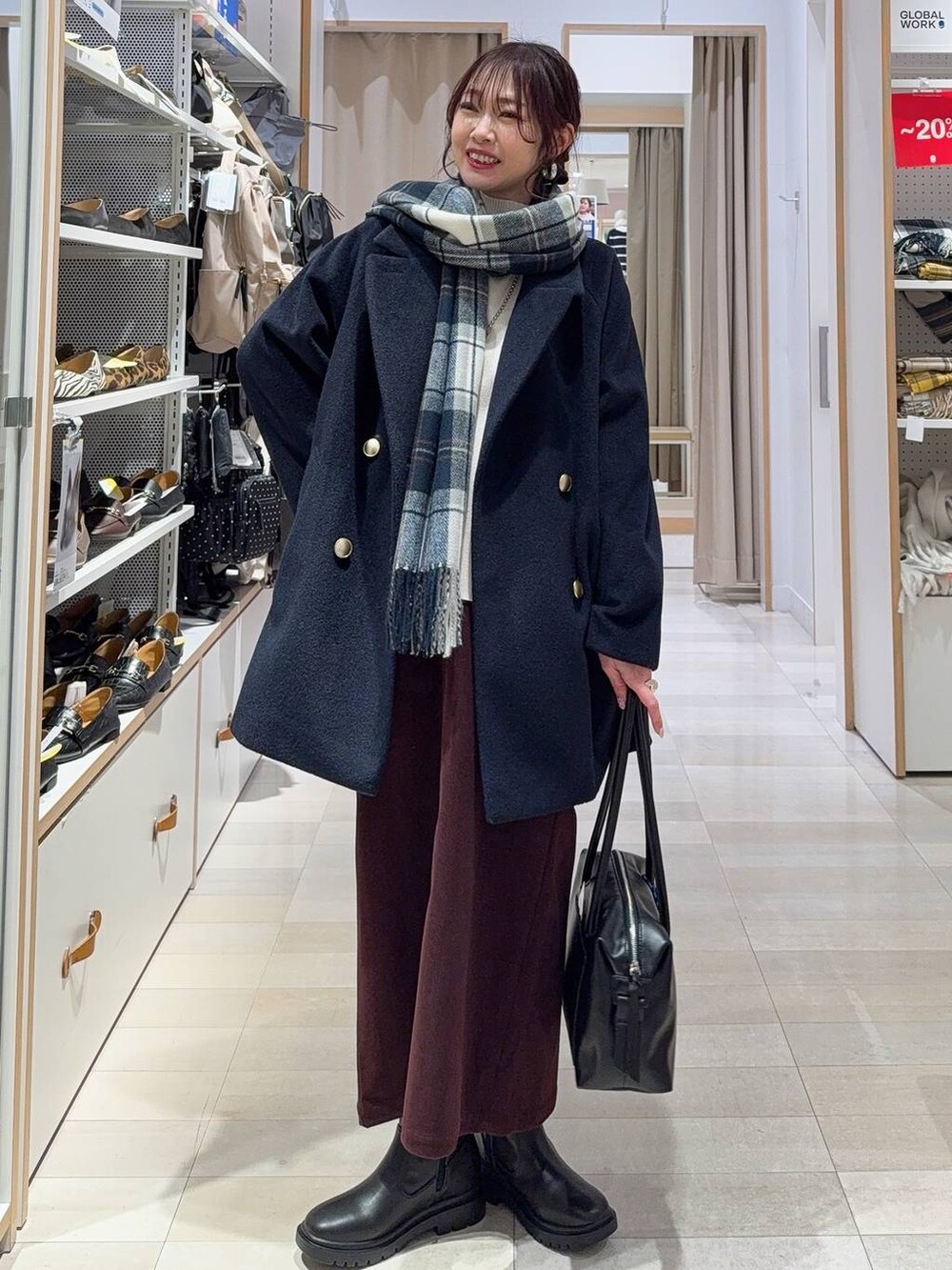 ブラック系のボストンバッグ、ブルー系のチェスターコート、レッド系のスカートを着用したレディースの冬コーディネートの2枚目の写真