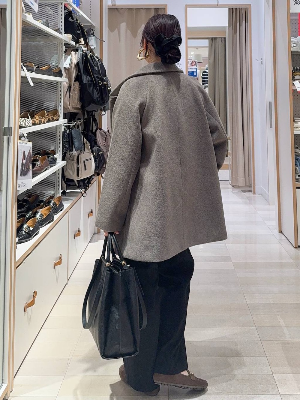 ブラウン系のチェスターコート、ブラック系のその他パンツ、ホワイト系のTシャツ/カットソーを着用したレディースの冬コーディネートの7枚目の写真