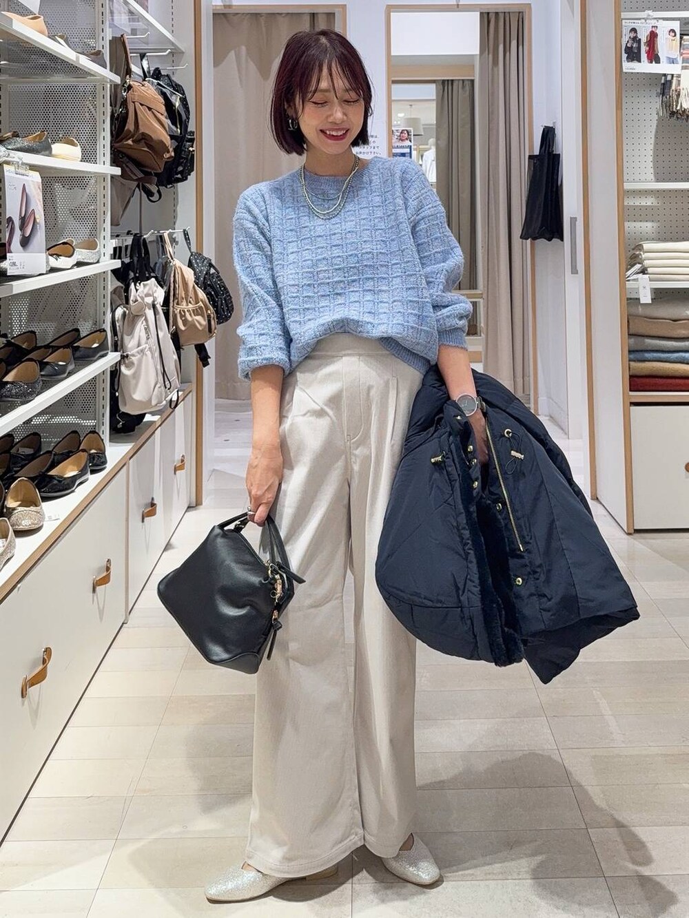 ブラック系のショルダーバッグ、シルバー系のパンプス、ブルー系のダウンジャケット/コートを着用したレディースの秋コーディネートの2枚目の写真