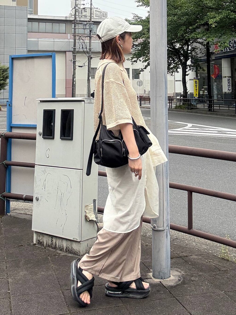 ベージュ系のその他パンツ、ブラック系のショルダーバッグ、ホワイト系のシャツ/ブラウスを着用したレディースの春コーディネートの3枚目の写真