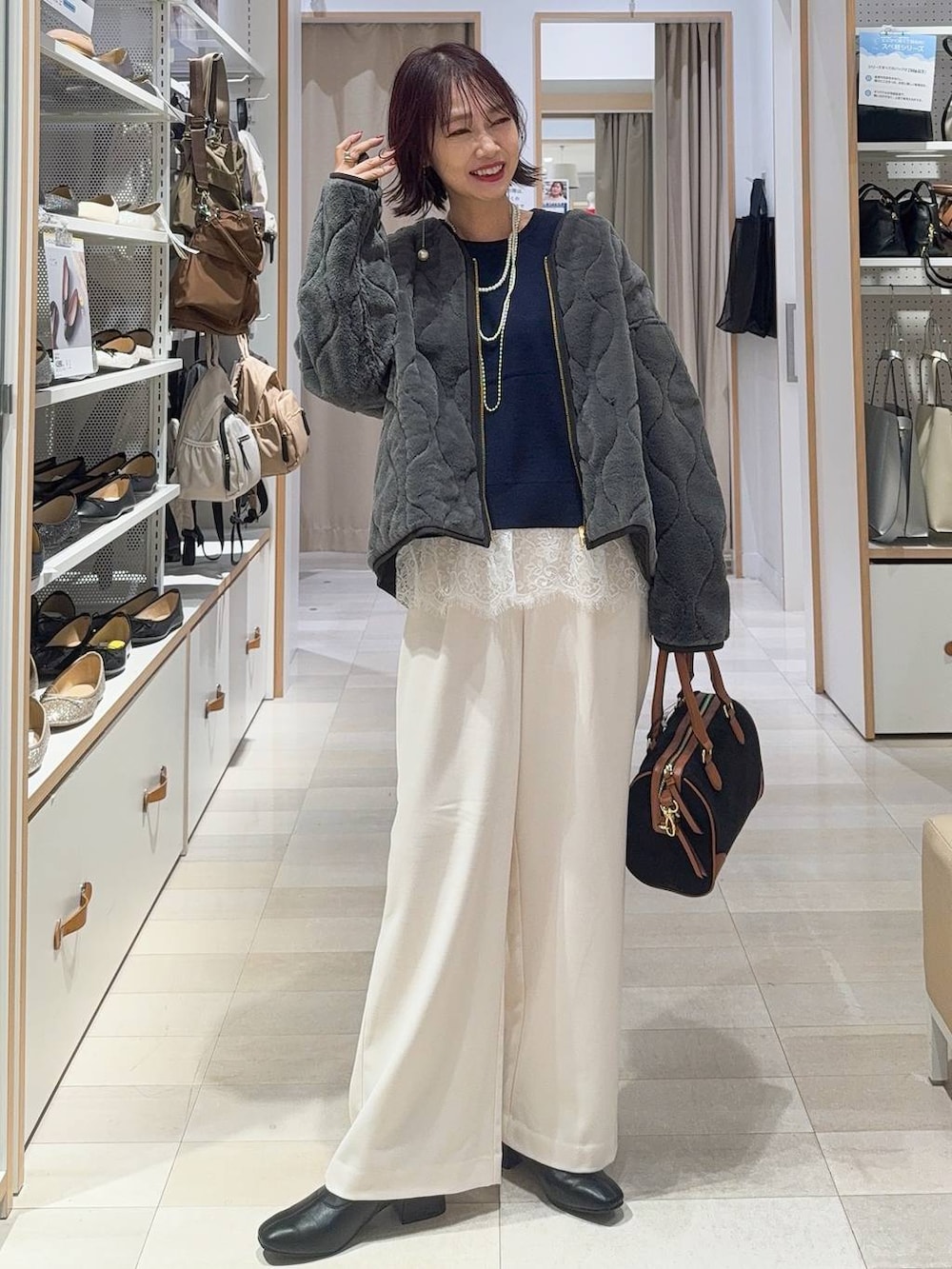 グレー系のブルゾン、グレー系のその他パンツ、ブラック系のボストンバッグを着用したレディースの秋コーディネートの2枚目の写真