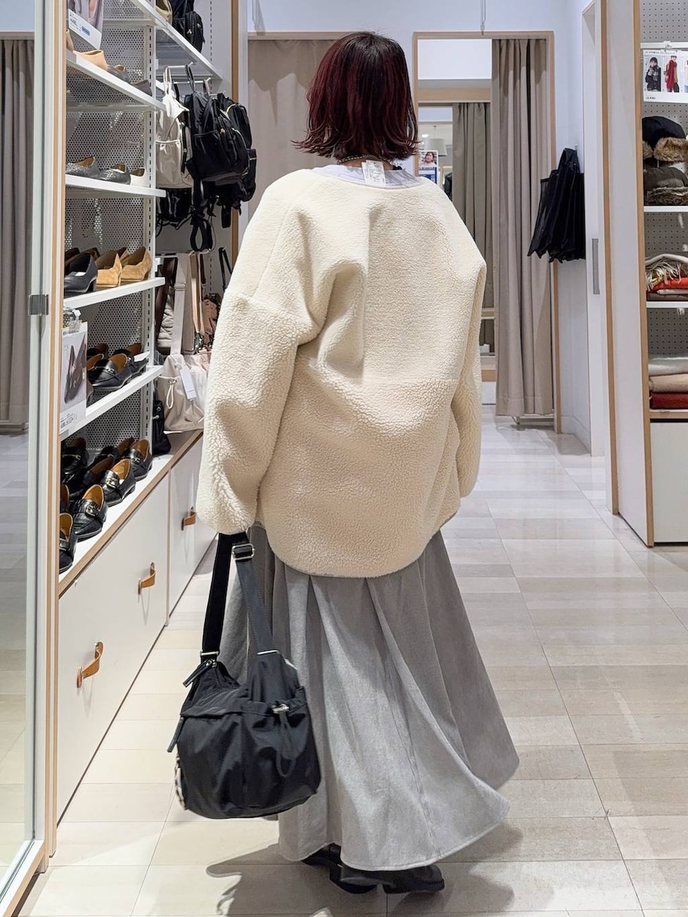 ブラック系のショルダーバッグ、グレー系のスカート、パープル系のスウェットを着用したレディースの冬コーディネートの4枚目の写真