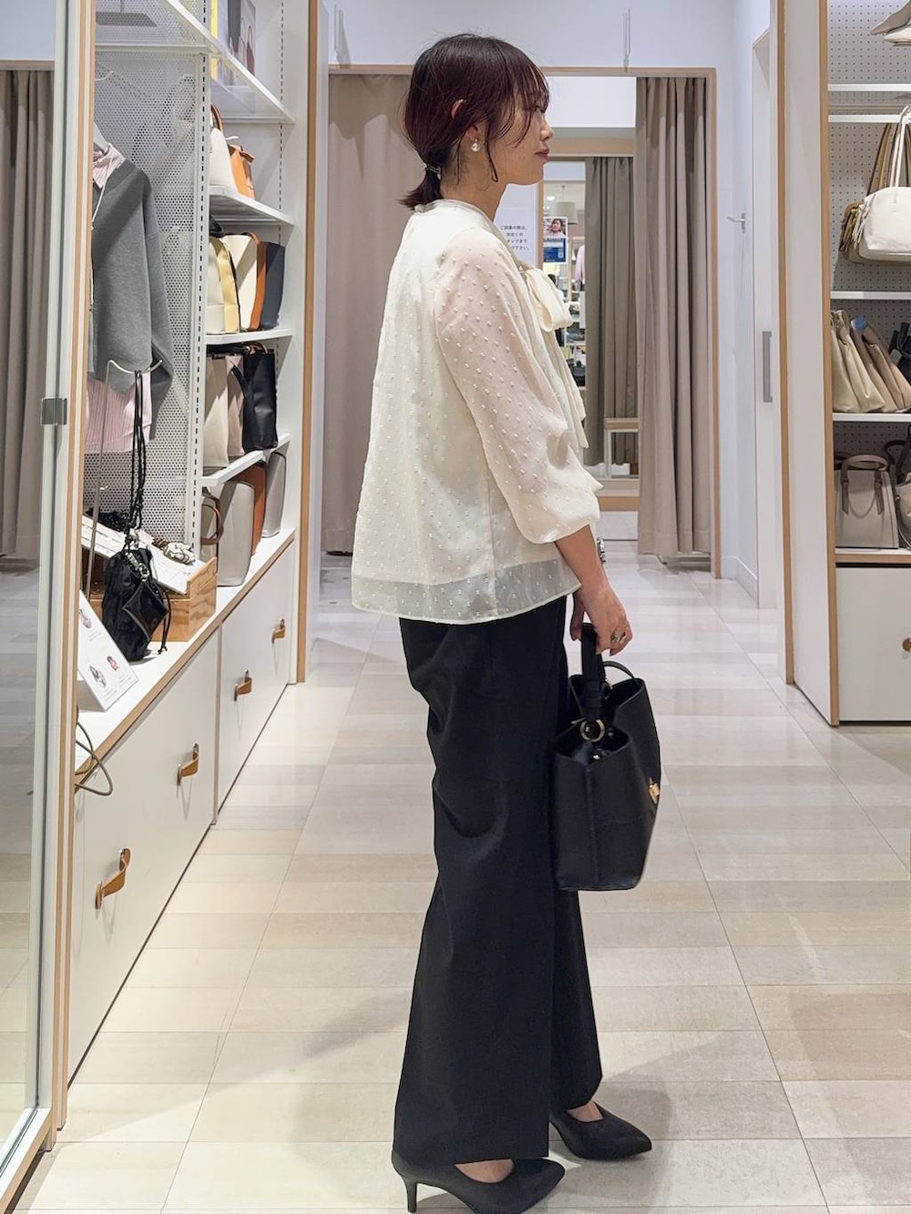 ブラック系のスラックス、ホワイト系のシャツ/ブラウス、ブラック系のその他アウターを着用したレディースの冬コーディネートの7枚目の写真