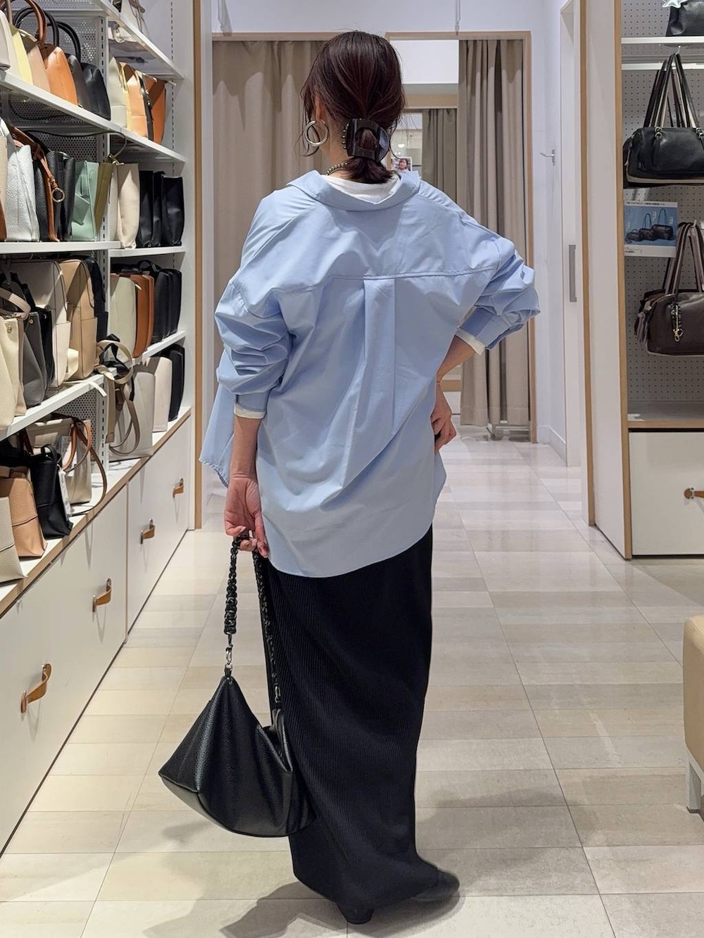 ブラック系のバレエシューズ、ブルー系のシャツ/ブラウス、ブラック系のスカートを着用したレディースの春コーディネートの7枚目の写真