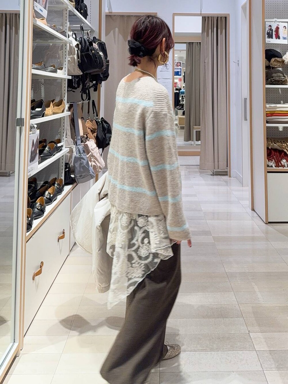 ゴールド系のバレエシューズ、ベージュ系のブルゾン、ブラウン系のボストンバッグを着用したレディースの冬コーディネートの5枚目の写真