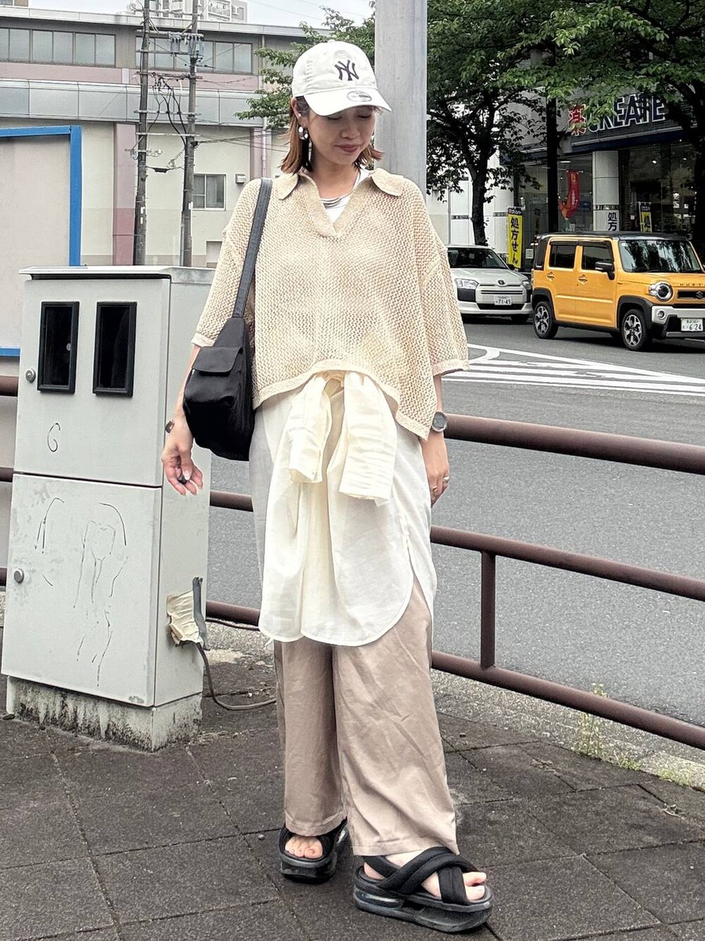 ベージュ系のその他パンツ、ブラック系のショルダーバッグ、ホワイト系のシャツ/ブラウスを着用したレディースの春コーディネートの2枚目の写真