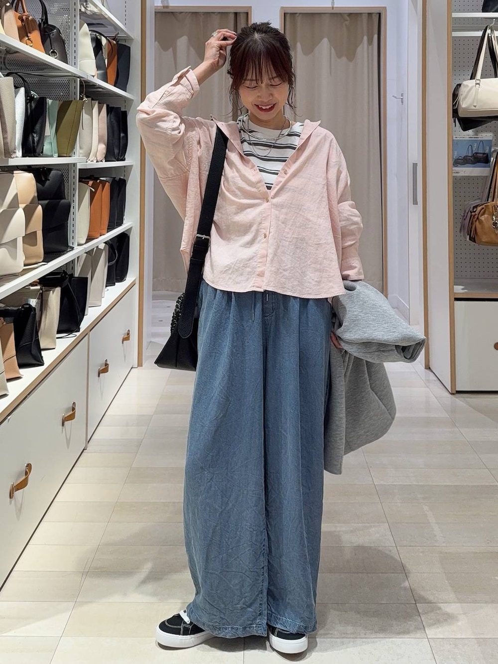 グレー系のブルゾン、ピンク系のシャツ/ブラウス、ブラウン系のボストンバッグを着用したレディースの春コーディネートの3枚目の写真