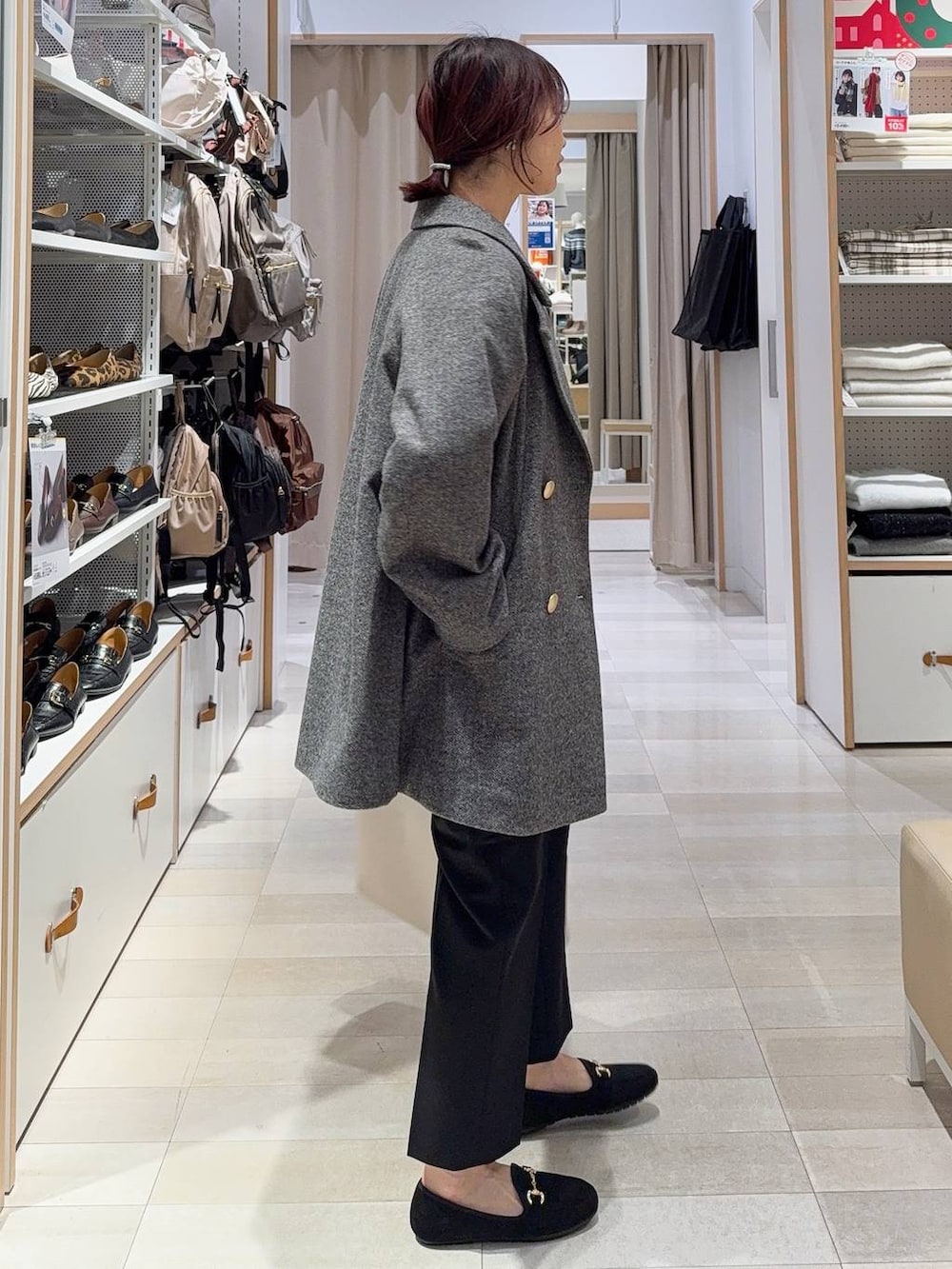 グレー系のチェスターコート、ブラック系のその他パンツ、ホワイト系のTシャツ/カットソーを着用したレディースの冬コーディネートの6枚目の写真