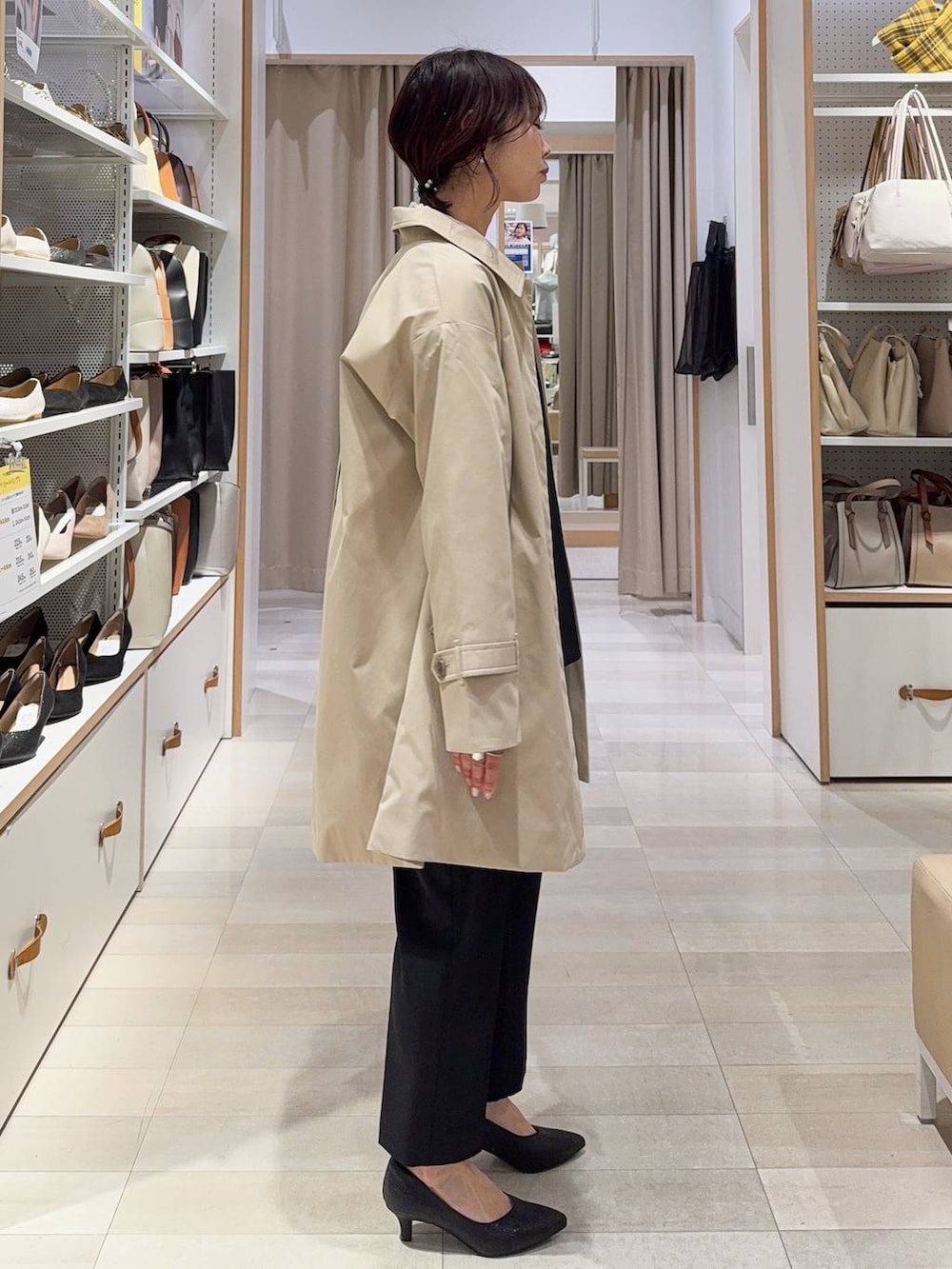 ホワイト系のショルダーバッグ、ブラック系のパンプス、ブラック系のセットアップを着用したレディースの冬コーディネートの4枚目の写真