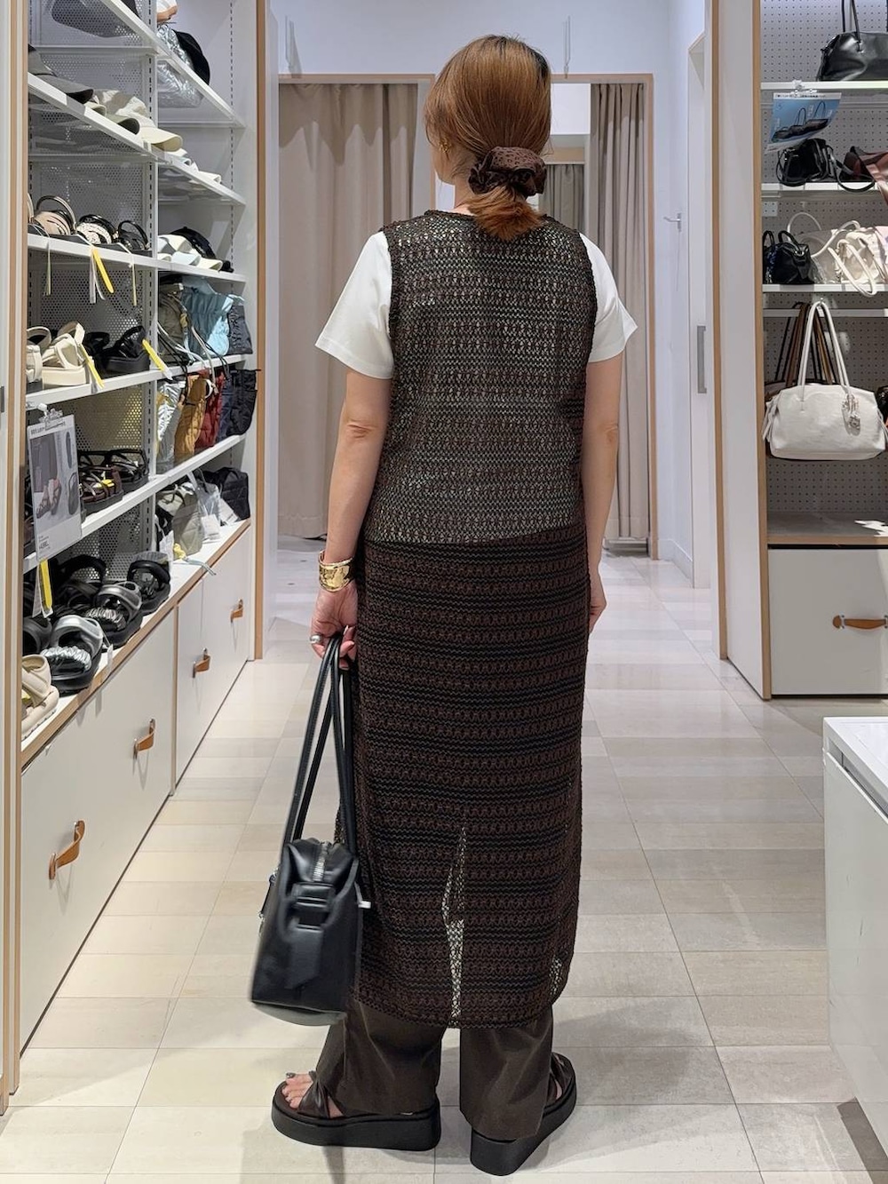 ブラック系のボストンバッグ、ブラウン系のその他パンツ、ホワイト系のTシャツ/カットソーを着用したレディースの夏コーディネートの5枚目の写真