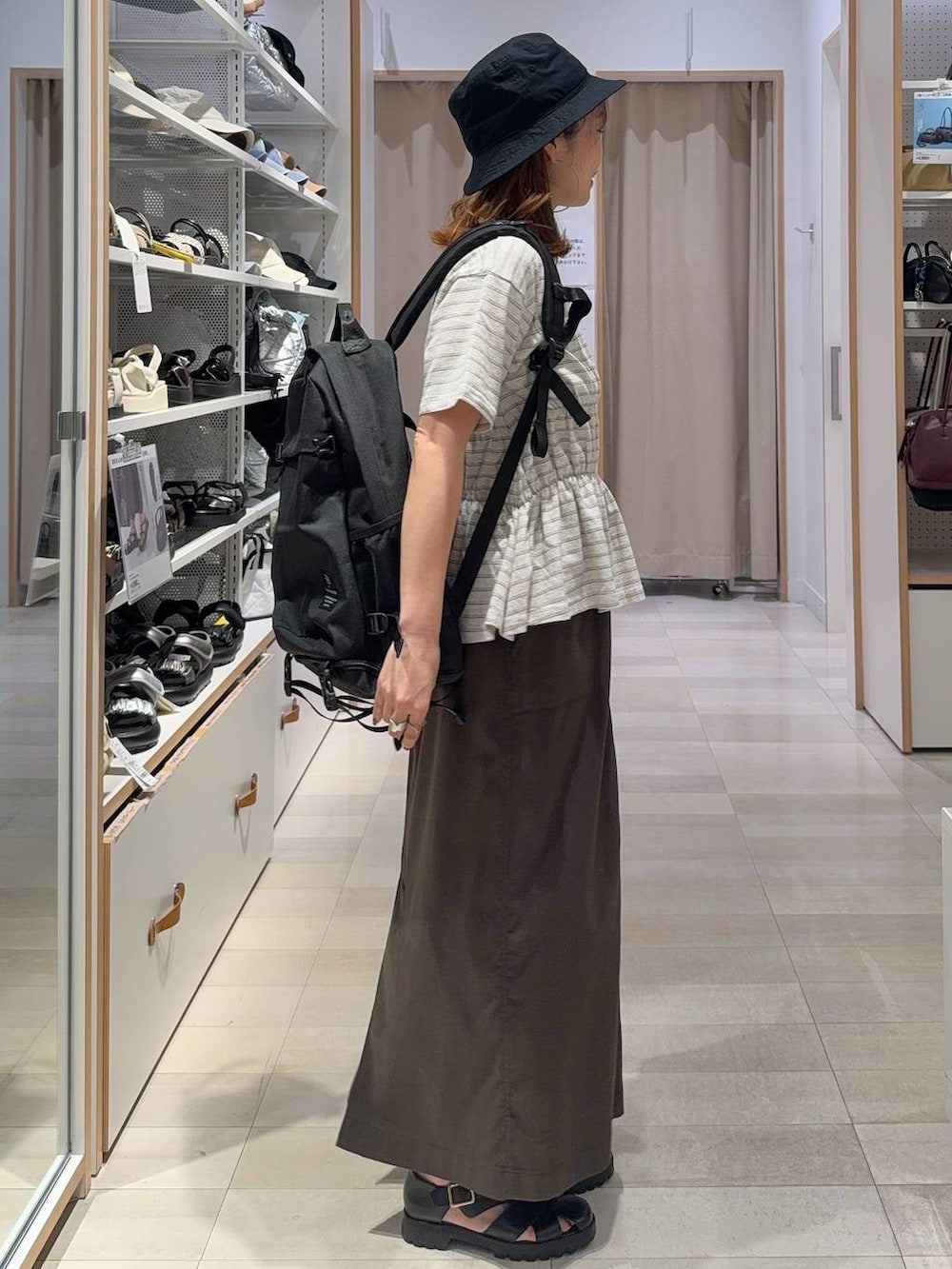ブラウン系のスカート、ブラック系のサンダル、ホワイト系のTシャツ/カットソーを着用したレディースの夏コーディネートの3枚目の写真
