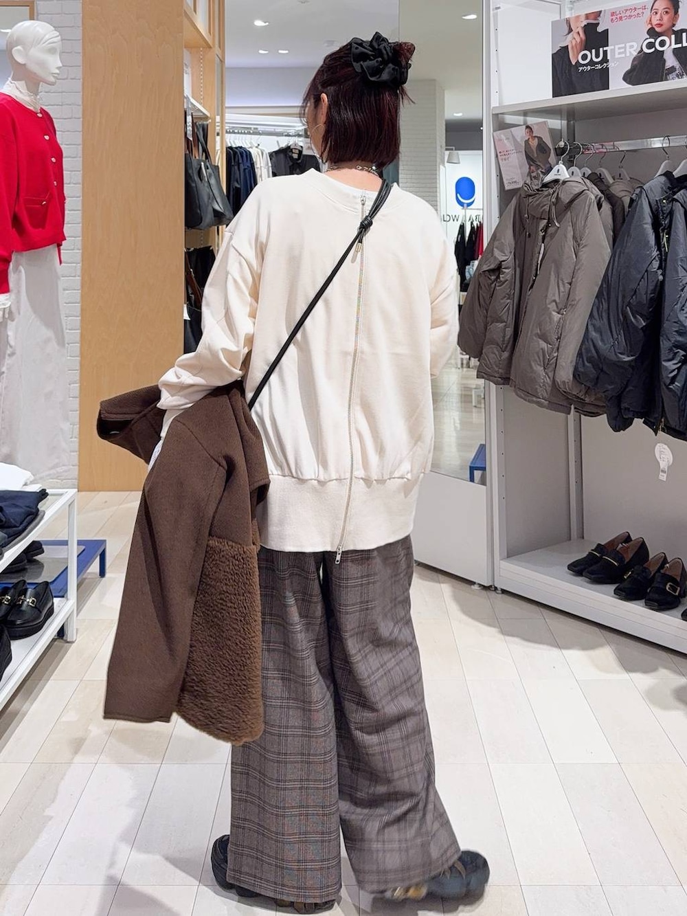 ブラック系のチェスターコート、ブラック系のショルダーバッグ、ホワイト系のTシャツ/カットソーを着用したレディースの秋コーディネートの9枚目の写真