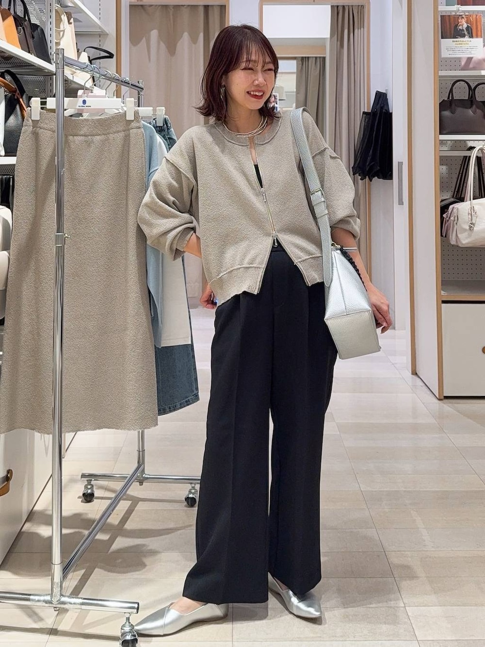 ブラック系のスニーカー、ベージュ系のワンピース、ホワイト系のTシャツ/カットソーを着用したレディースの春コーディネートの6枚目の写真