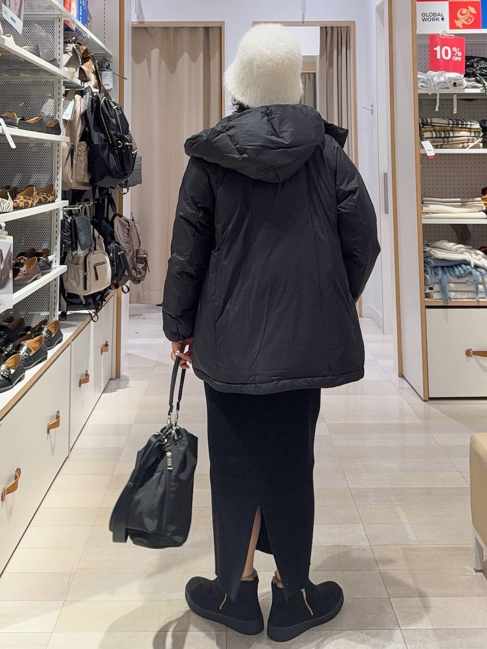 ブラック系のショルダーバッグ、ブラック系のダウンジャケット/コート、ブルー系のニット/セーターを着用したレディースの冬コーディネートの5枚目の写真