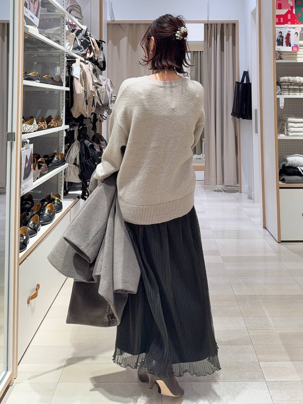 ブラウン系のショルダーバッグ、ブラウン系のチェスターコート、グレー系のワンピースを着用したレディースの冬コーディネートの8枚目の写真