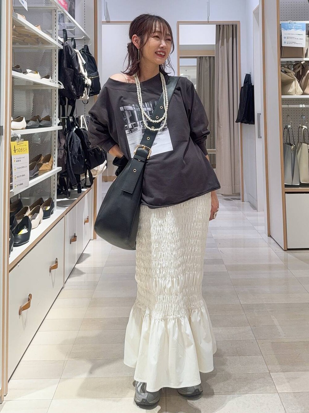 グレー系のスウェット、ブラック系のデニムパンツ、ブラック系のその他トップスを着用したレディースの秋コーディネートの4枚目の写真