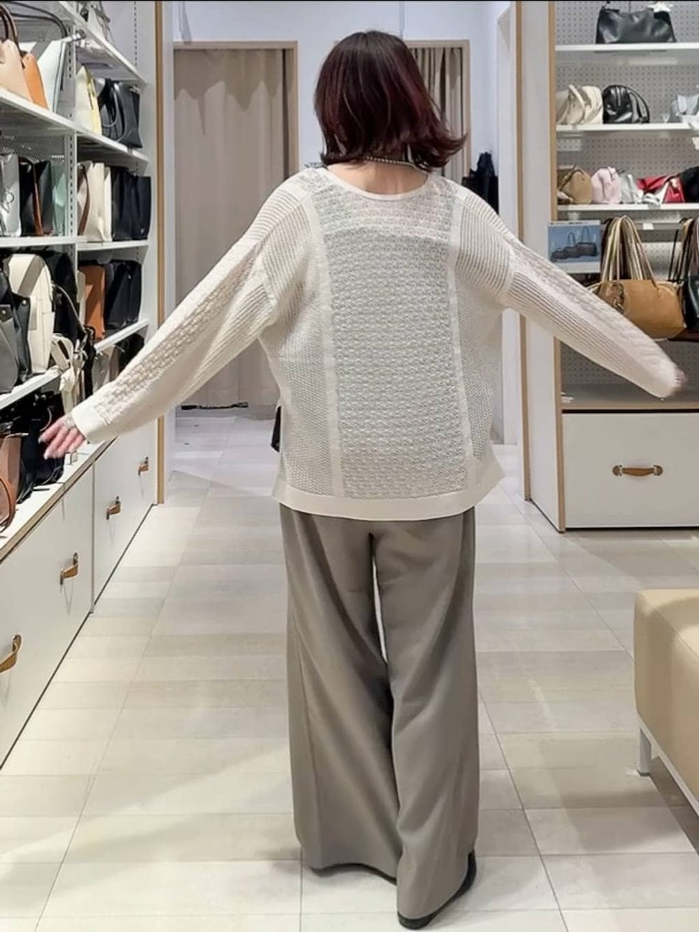 ブラック系のパンプス、ブラウン系のその他パンツ、シルバー系のネックレスを着用したレディースの春コーディネートの3枚目の写真