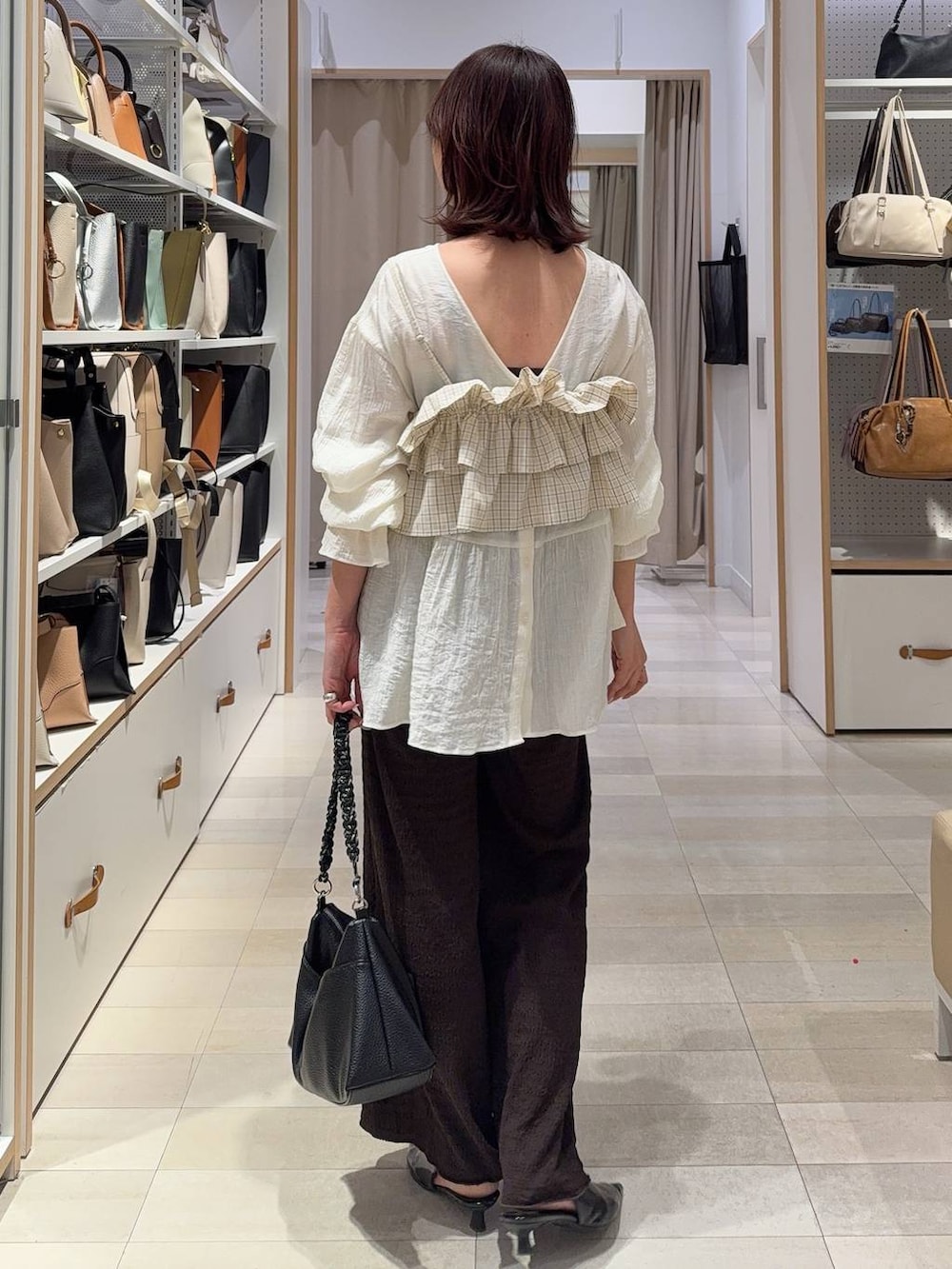 ホワイト系のブルゾン、ブラウン系のキャミソール、ブラウン系のその他パンツを着用したレディースの春コーディネートの9枚目の写真