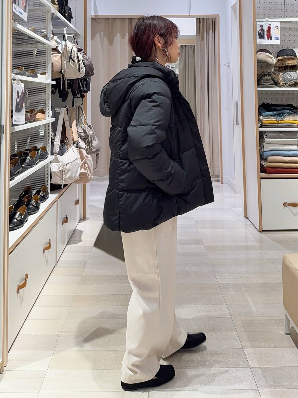 ブラック系のダウンジャケット/コート、グリーン系のショルダーバッグ、ブラック系のニット/セーターを着用したレディースの秋コーディネートの6枚目の写真