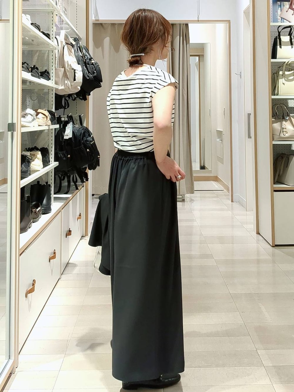 ブラック系のローファー、グレー系のボストンバッグ、ホワイト系のTシャツ/カットソーを着用したレディースの春コーディネートの5枚目の写真