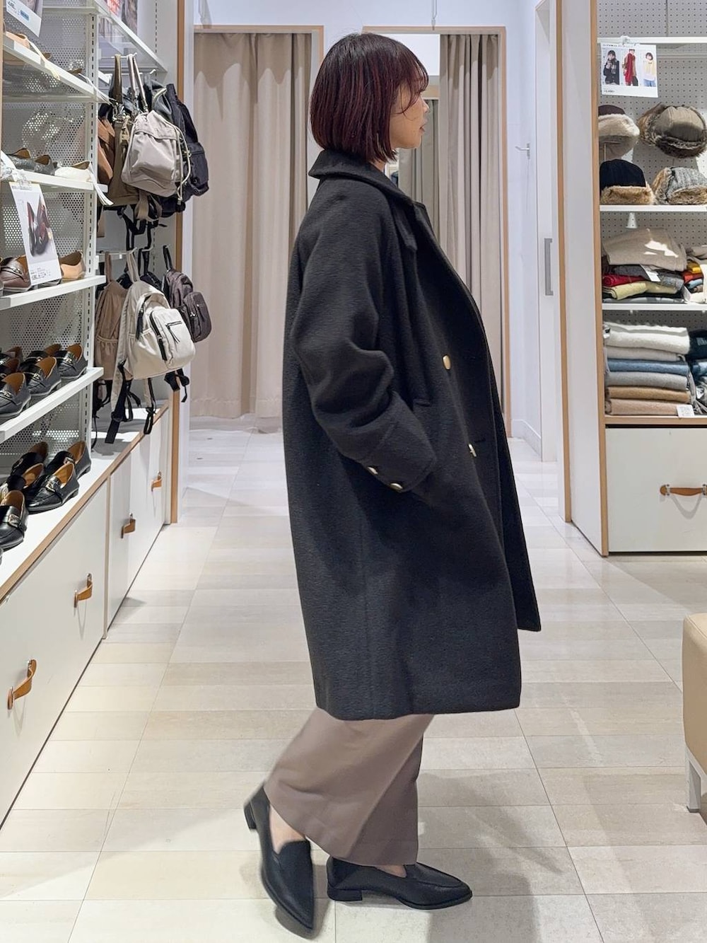 グリーン系のショルダーバッグ、ブラック系のチェスターコート、ブラック系のスウェットを着用したレディースの秋コーディネートの4枚目の写真