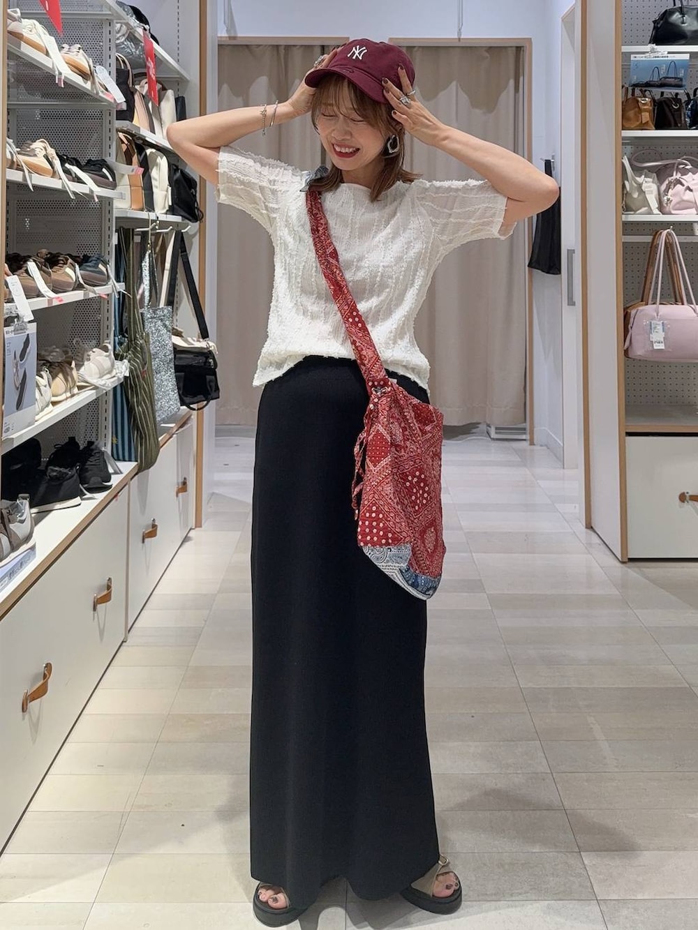 ブラック系のベスト、ホワイト系のTシャツ/カットソー、ブラック系のスカートを着用したレディースの夏コーディネートの4枚目の写真