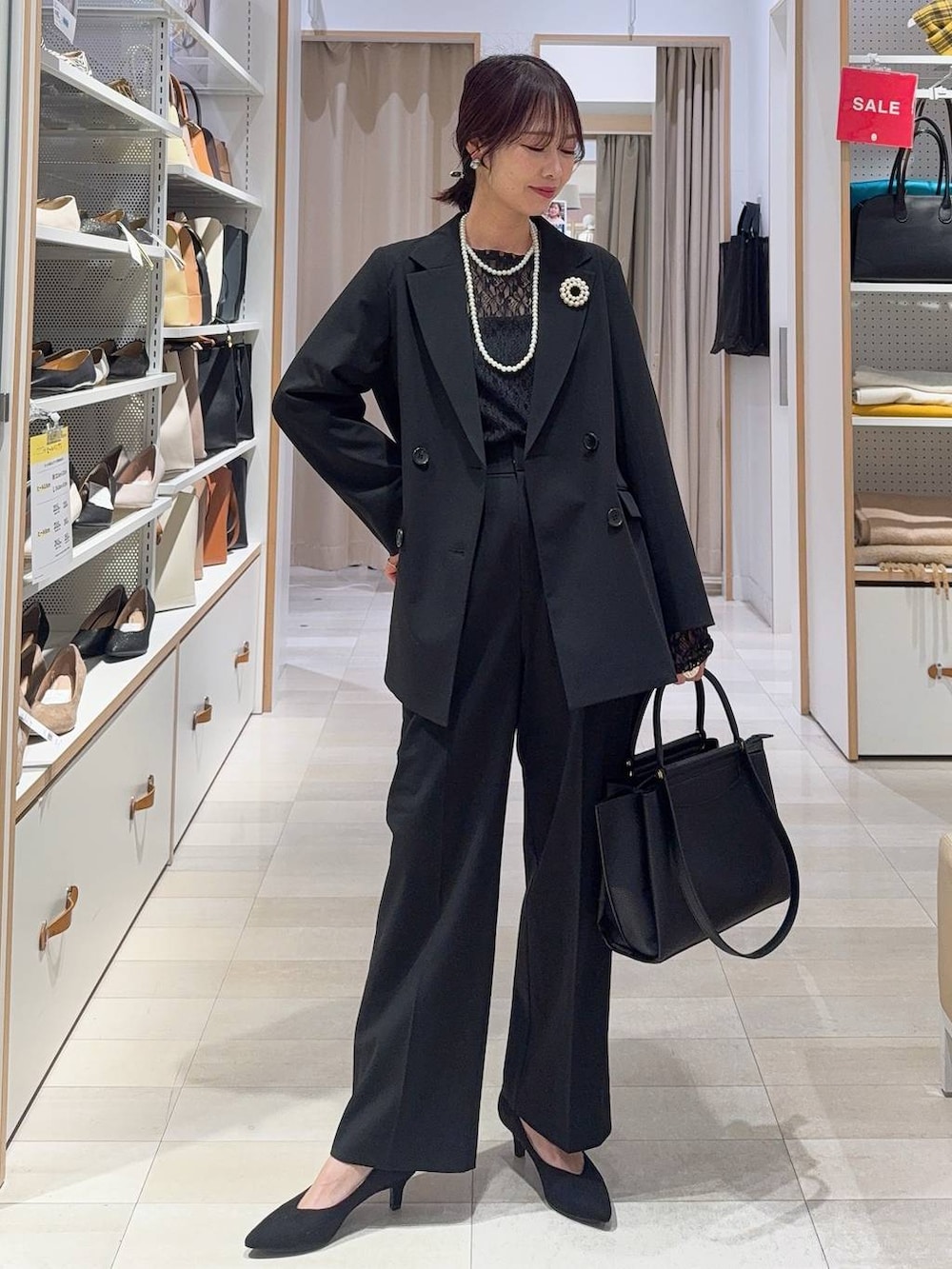 ブラック系のキャミソール、ブラック系のテーラードジャケット、ブルー系のデニムパンツを着用したレディースの冬コーディネートの3枚目の写真