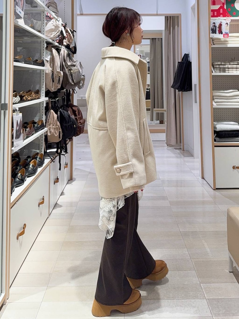 ブラック系のショルダーバッグ、イエロー系のブーツ、ホワイト系のニット/セーターを着用したレディースの冬コーディネートの6枚目の写真