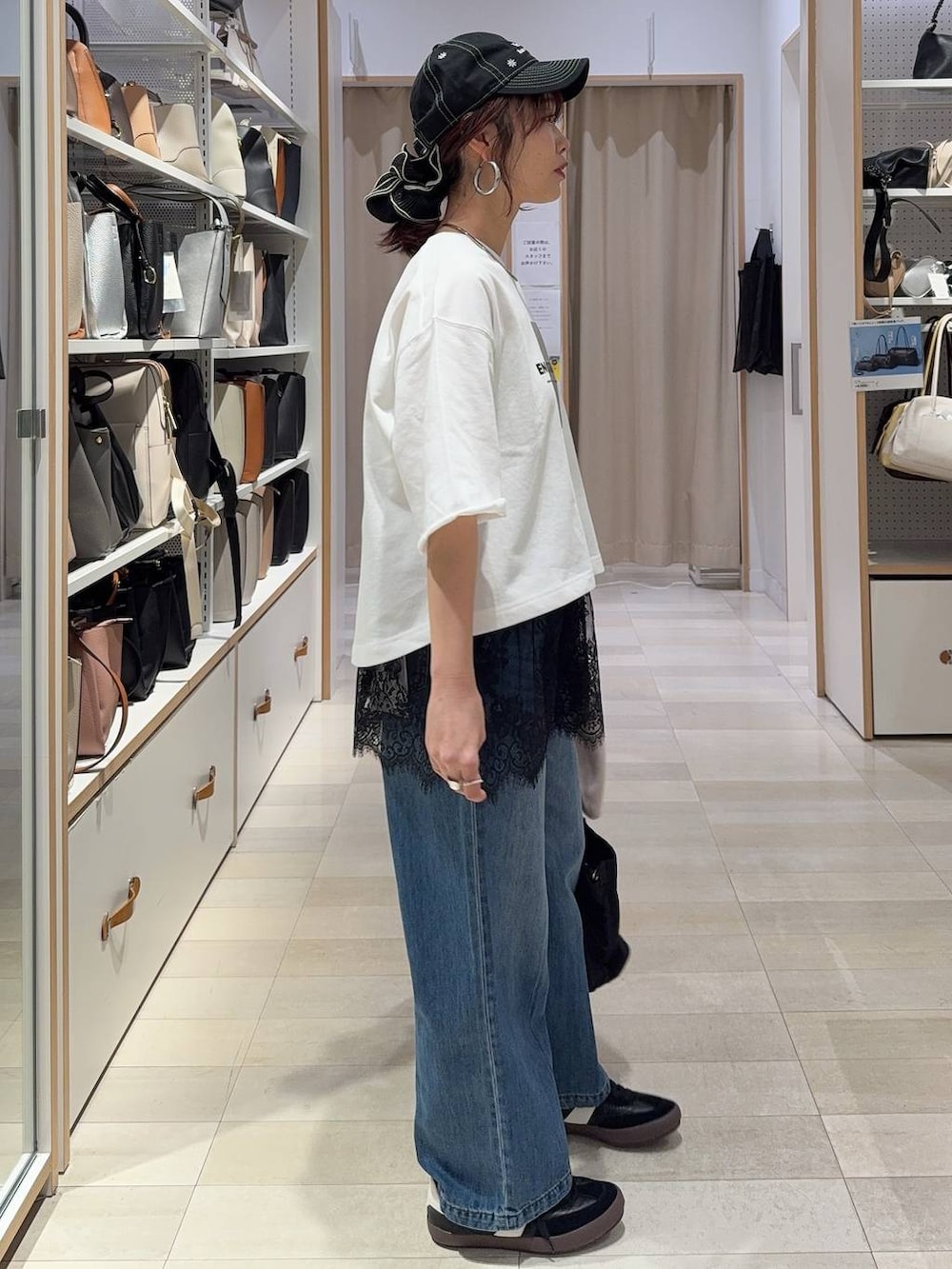 ブラック系のスニーカー、ブルー系のデニムパンツ、ベージュ系のパーカーを着用したレディースの春コーディネートの6枚目の写真