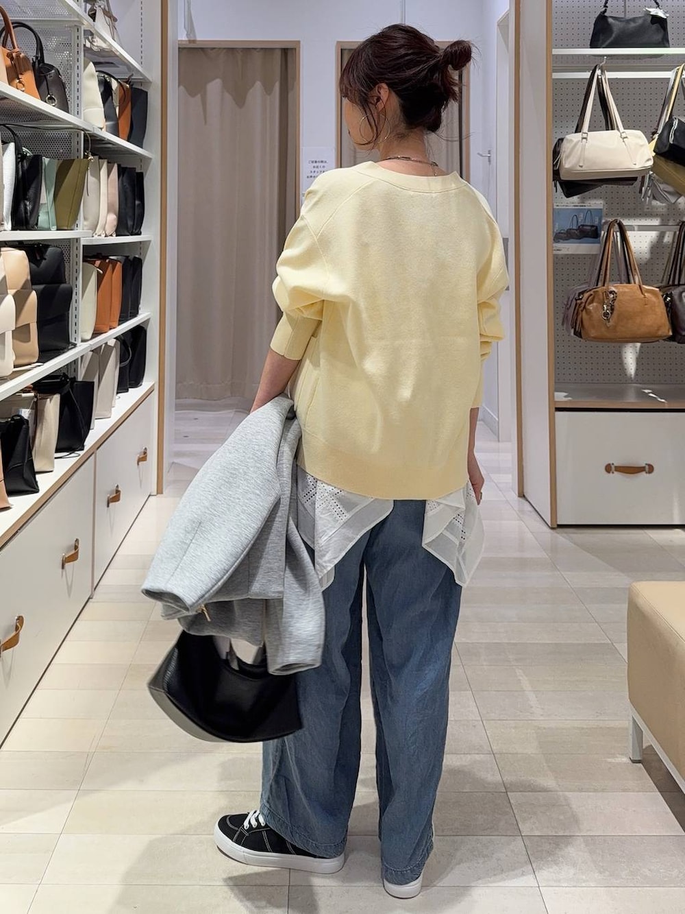 グレー系のブルゾン、イエロー系のカーディガン/ボレロ、ブラック系のスニーカーを着用したレディースの春コーディネートの7枚目の写真