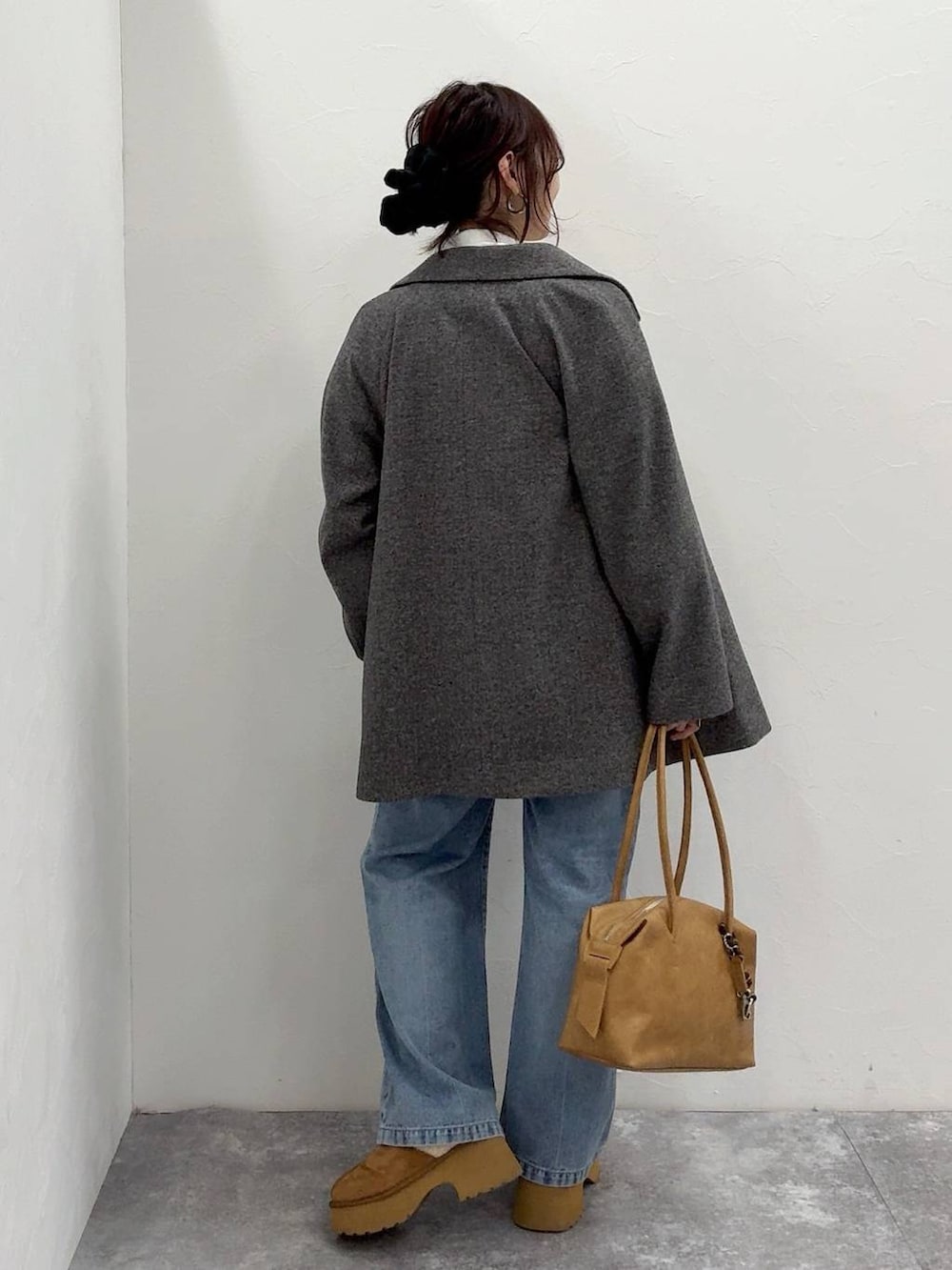 ベージュ系のボストンバッグ、グレー系のチェスターコート、イエロー系のブーツを着用したレディースの冬コーディネートの7枚目の写真