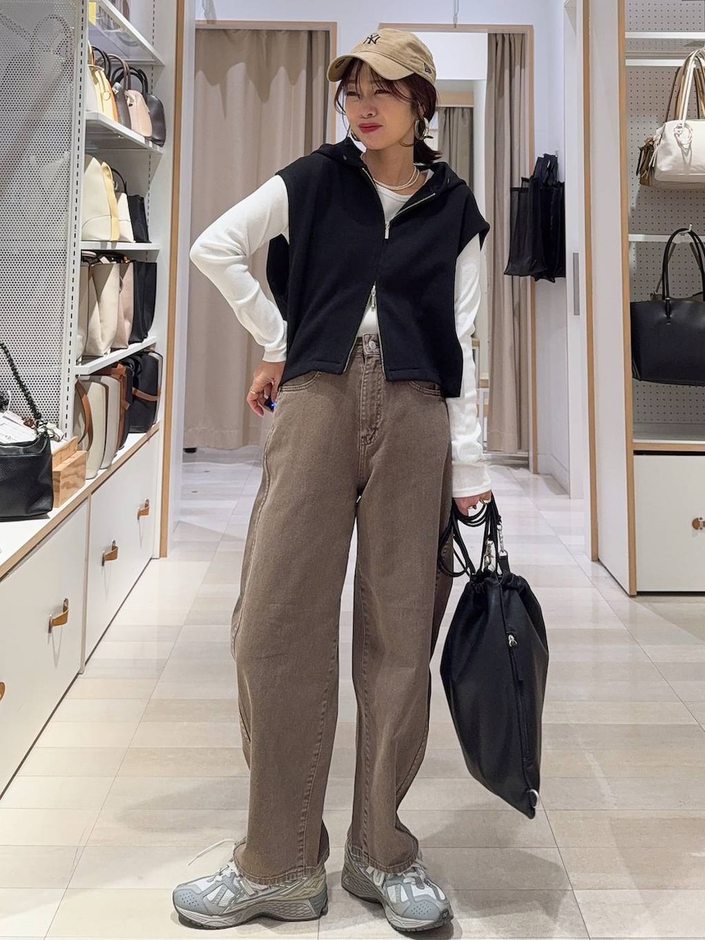 ブラック系のスニーカー、ブルー系のシャツ/ブラウス、ブラック系のベストを着用したレディースの冬コーディネートの2枚目の写真