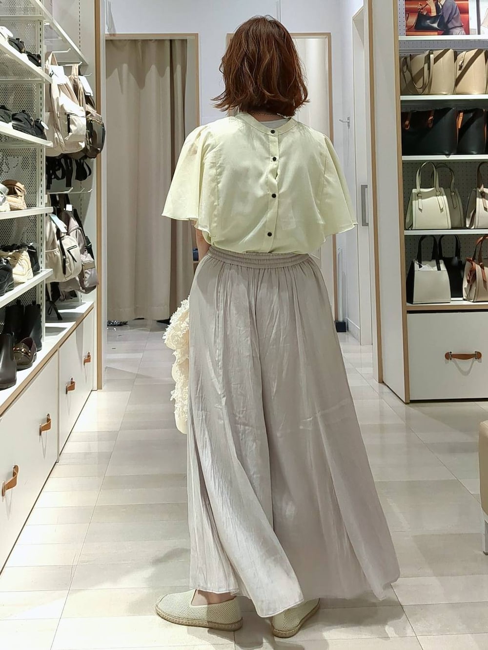 ベージュ系のその他パンツ、ホワイト系のショルダーバッグ、ホワイト系のスリッポンを着用したレディースの春コーディネートの7枚目の写真