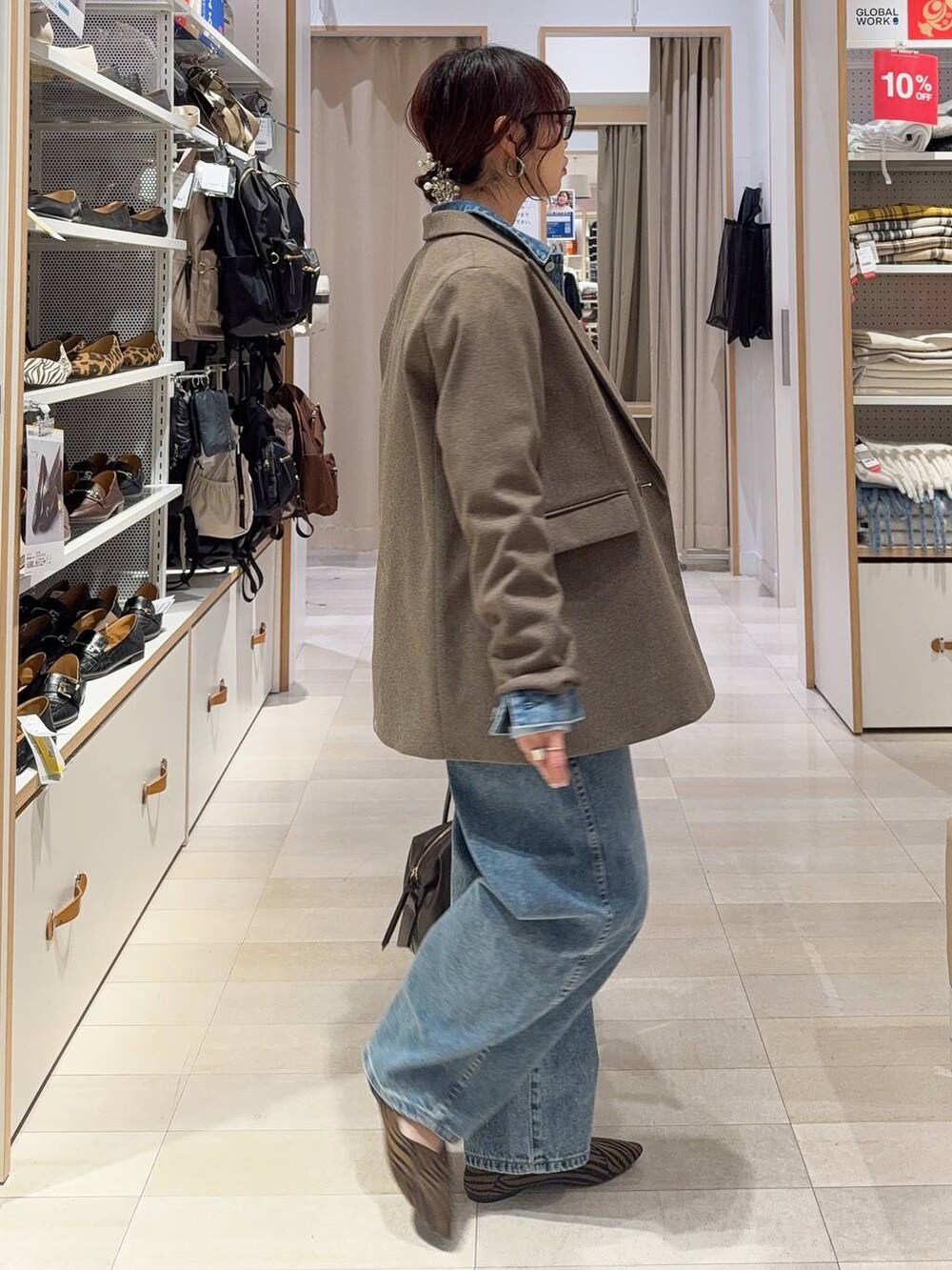 その他のパンプス、ブラウン系のボストンバッグ、ブルー系のデニムパンツを着用したレディースの冬コーディネートの4枚目の写真