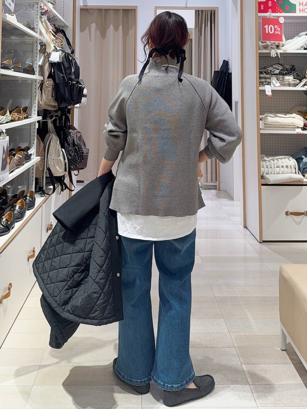 グリーン系のショルダーバッグ、ブラック系のステンカラーコート、ホワイト系のTシャツ/カットソーを着用したレディースの冬コーディネートの7枚目の写真