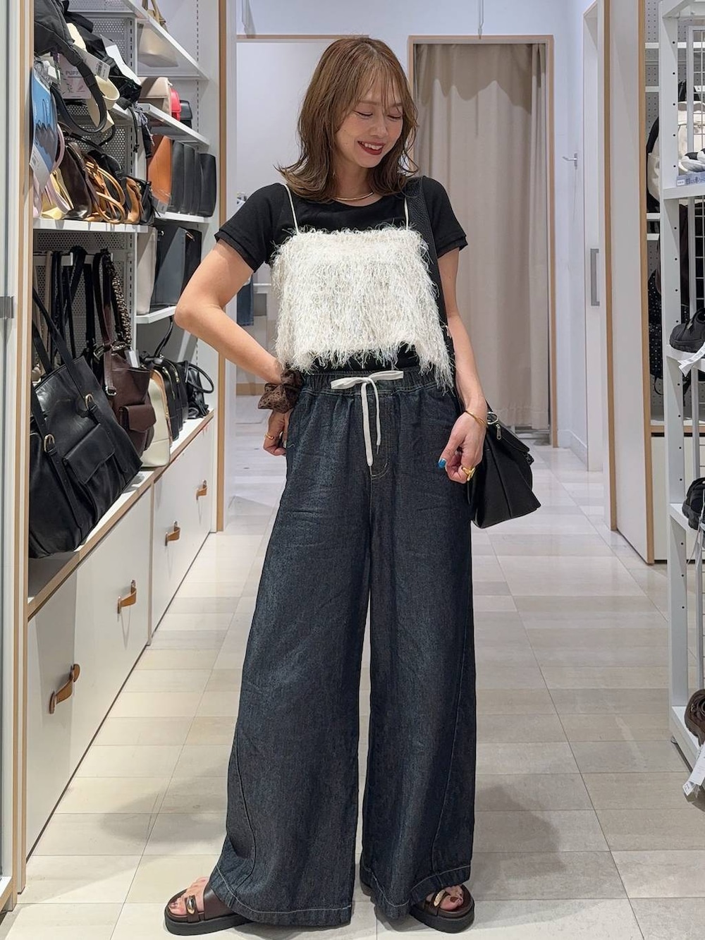 ブラウン系のサンダル、ブラック系のTシャツ/カットソー、ベージュ系のその他トップスを着用したレディースの夏コーディネートの2枚目の写真