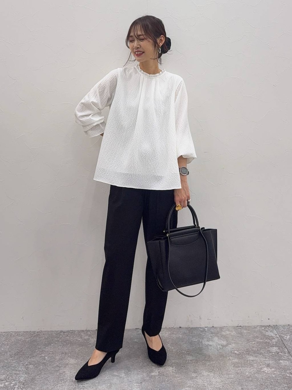 ブラック系のパンプス、ホワイト系のシャツ/ブラウス、ブラック系のスラックスを着用したレディースの冬コーディネートの3枚目の写真