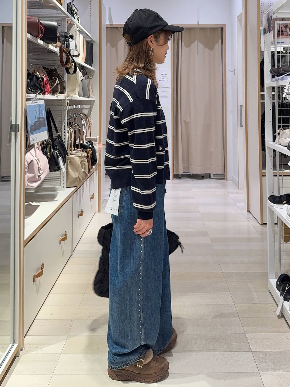ブルー系のデニムパンツ、ホワイト系のTシャツ/カットソー、ブラック系のトートバッグを着用したレディースの秋コーディネートの2枚目の写真