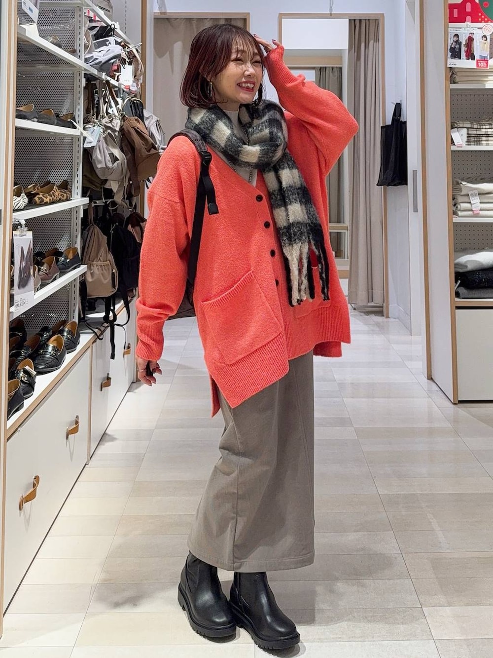 ブラウン系のバックパック/リュック、ブラウン系のスカート、ブラック系のブーツを着用したレディースの冬コーディネートの2枚目の写真