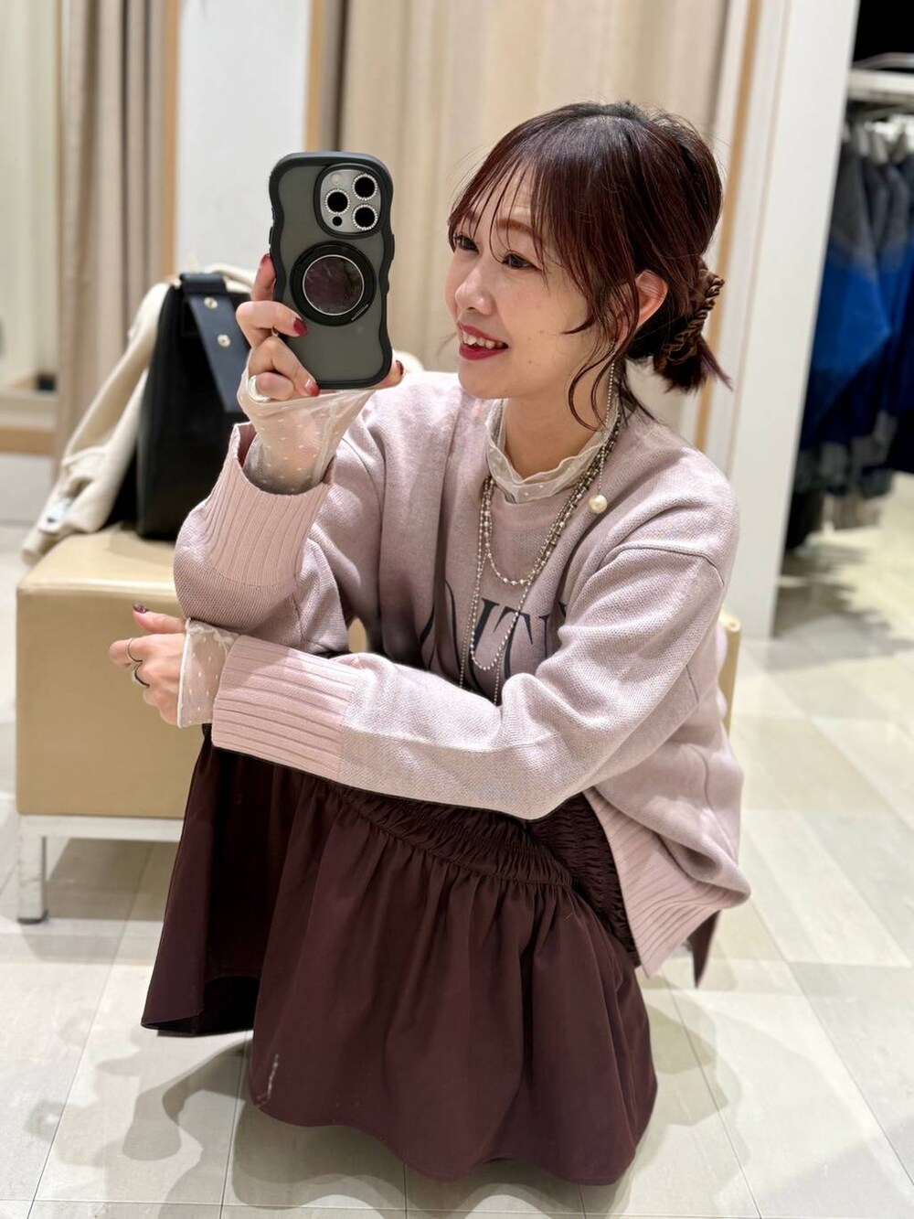 ブラック系のショルダーバッグ、ホワイト系のTシャツ/カットソー、ブラック系のブーツを着用したレディースの冬コーディネートの2枚目の写真