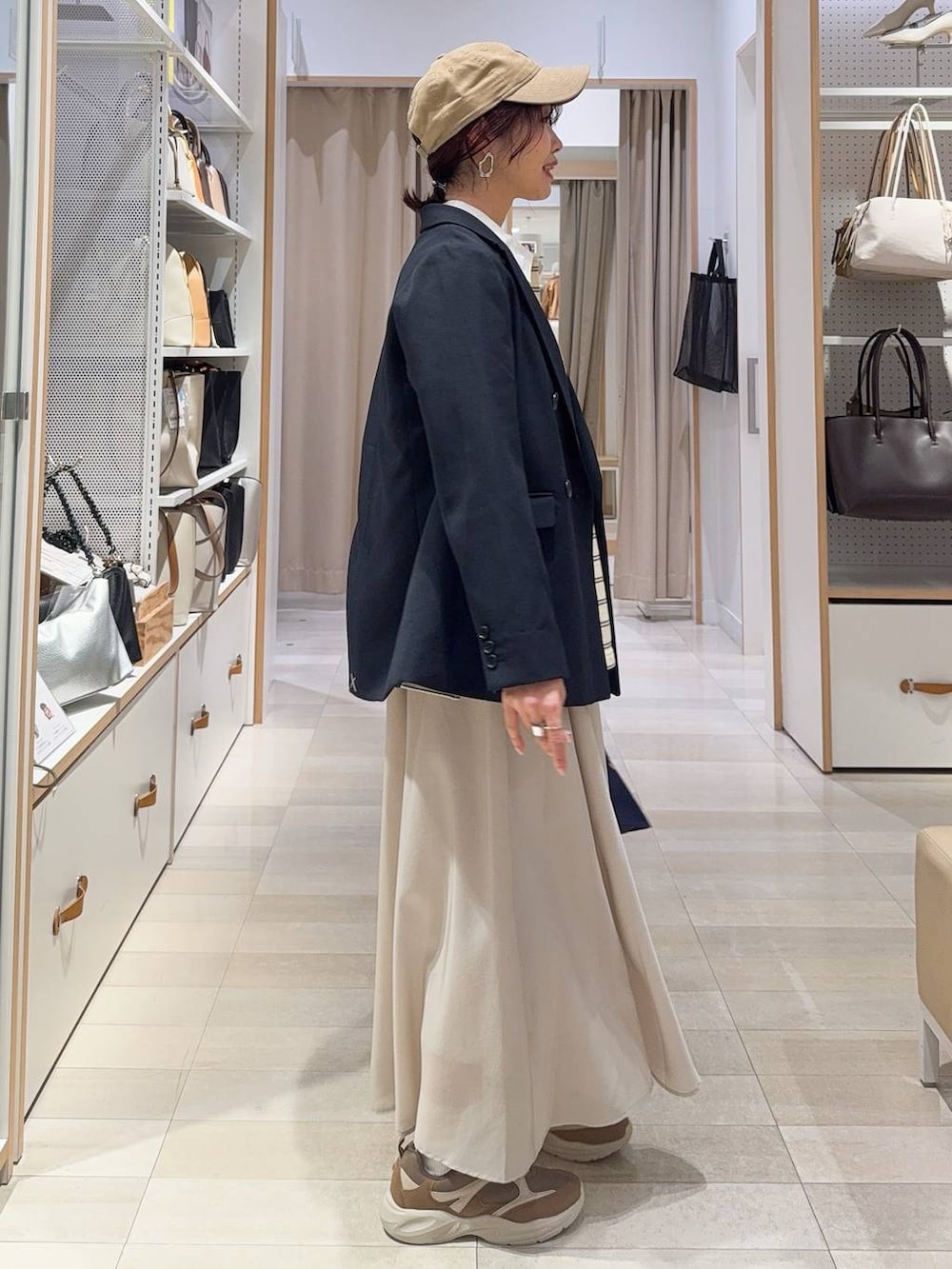 ベージュ系のスカート、ブラウン系のその他シューズ、ブルー系のトートバッグを着用したレディースの冬コーディネートの6枚目の写真