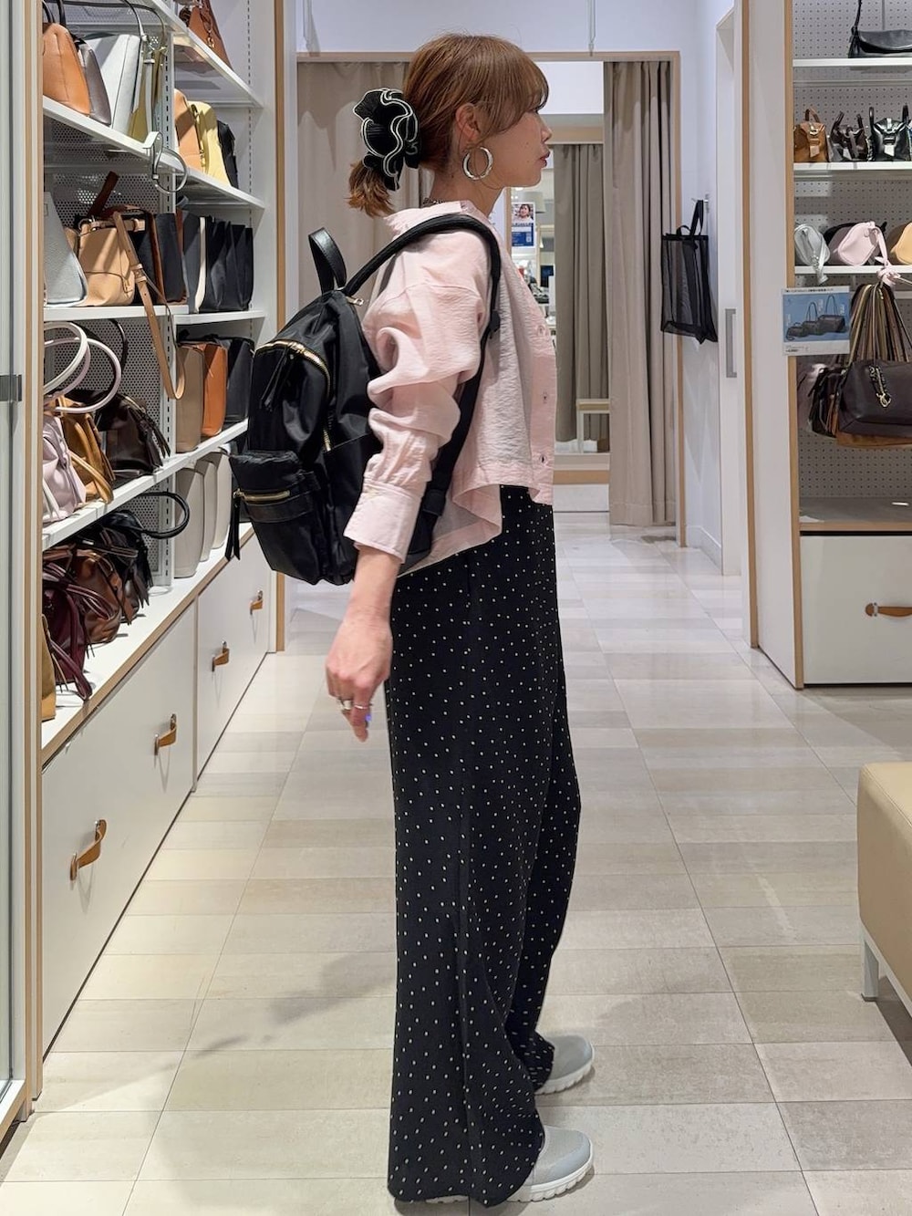 グレー系のスニーカー、ブラック系のバックパック/リュック、ピンク系のシャツ/ブラウスを着用したレディースの春コーディネートの3枚目の写真