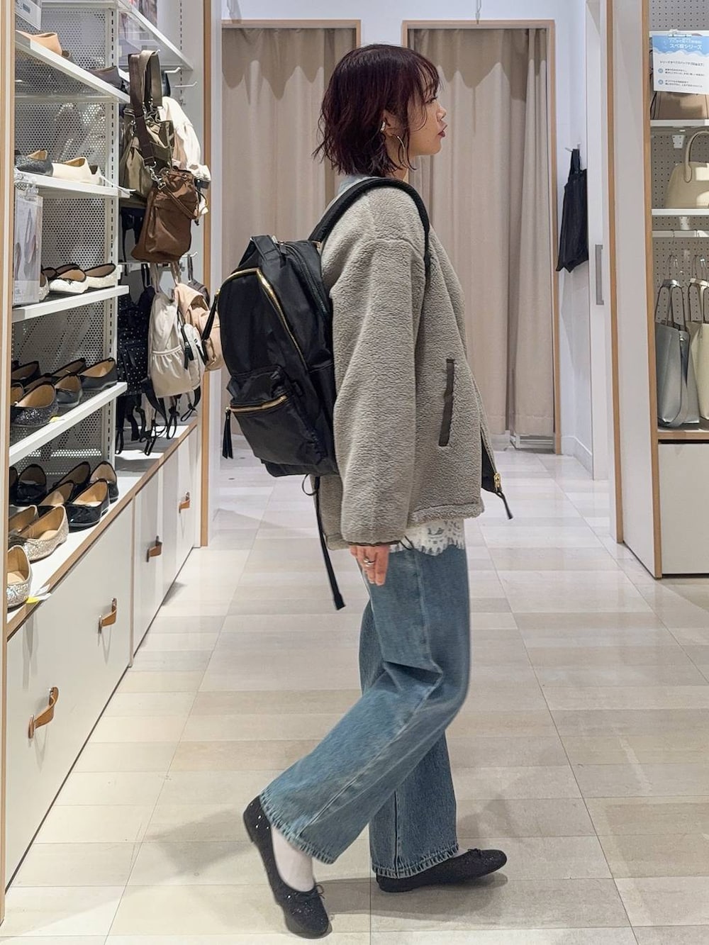 ブラック系のバレエシューズ、グレー系のブルゾン、ブルー系のデニムパンツを着用したレディースの秋コーディネートの4枚目の写真