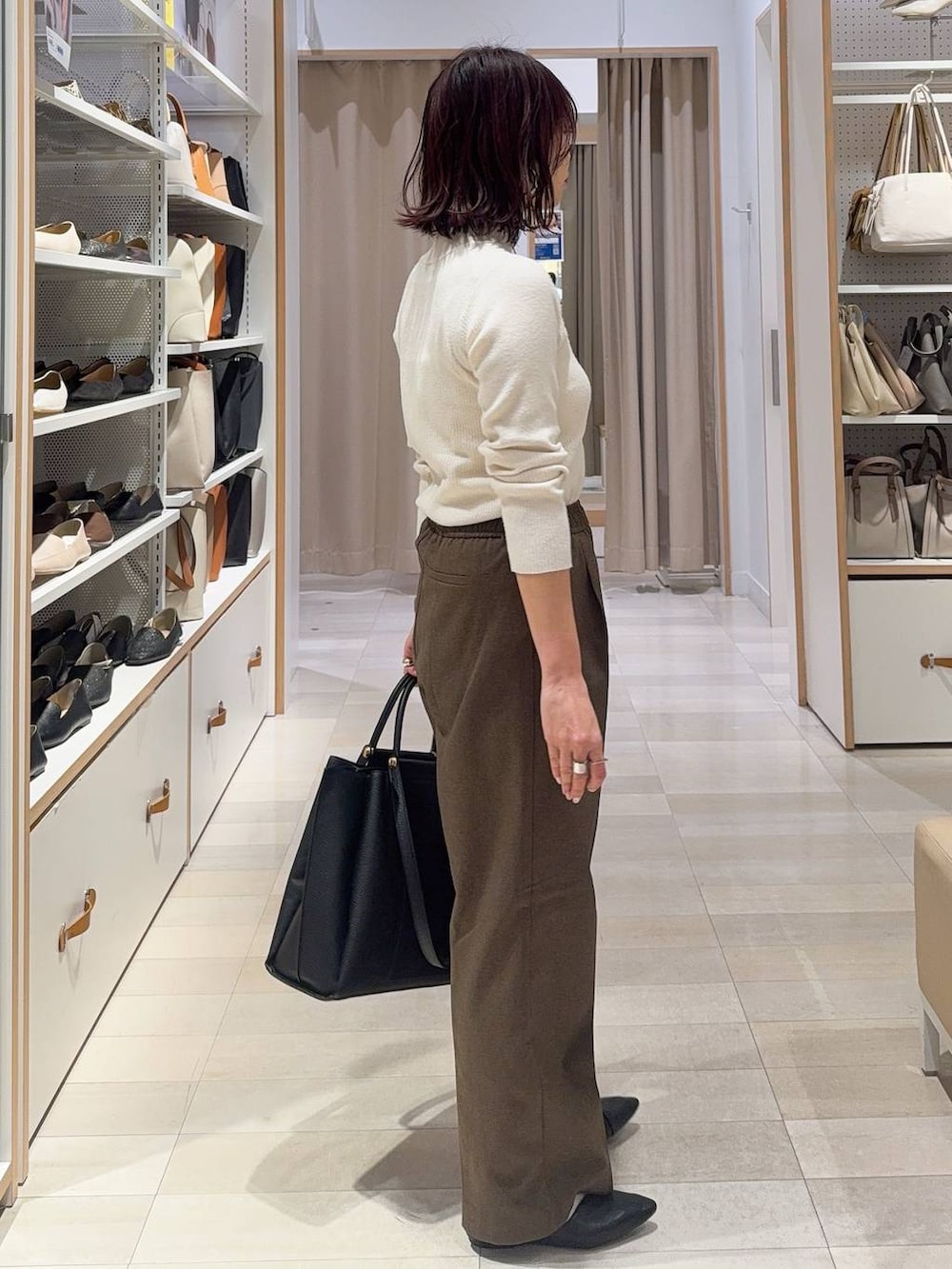 ブラック系のパンプス、ホワイト系のニット/セーター、ブラウン系のその他パンツを着用したレディースの冬コーディネートの7枚目の写真