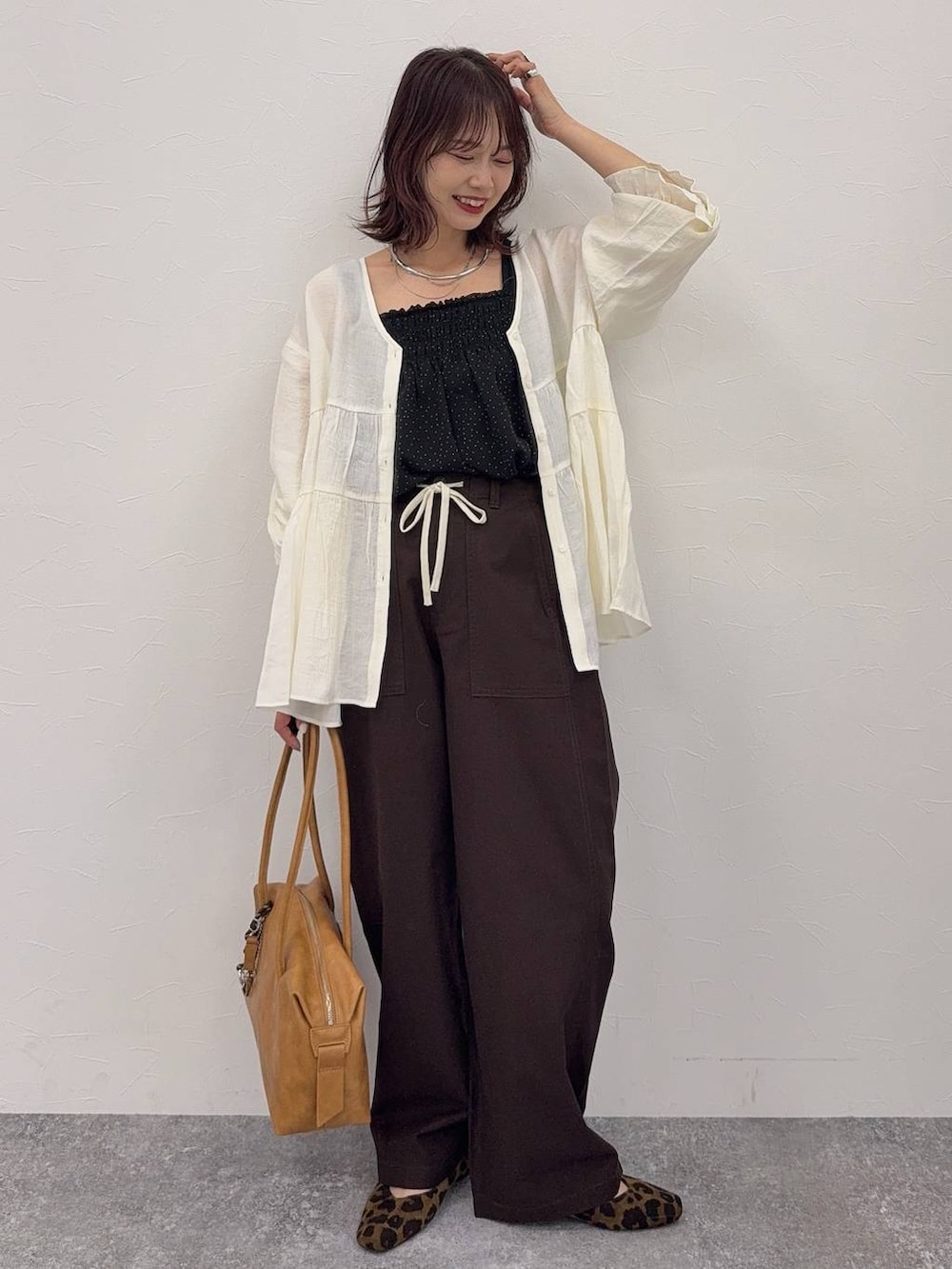 ブラック系のバレエシューズ、レッド系のショルダーバッグ、ブラウン系のワンピースを着用したレディースの春コーディネートの5枚目の写真