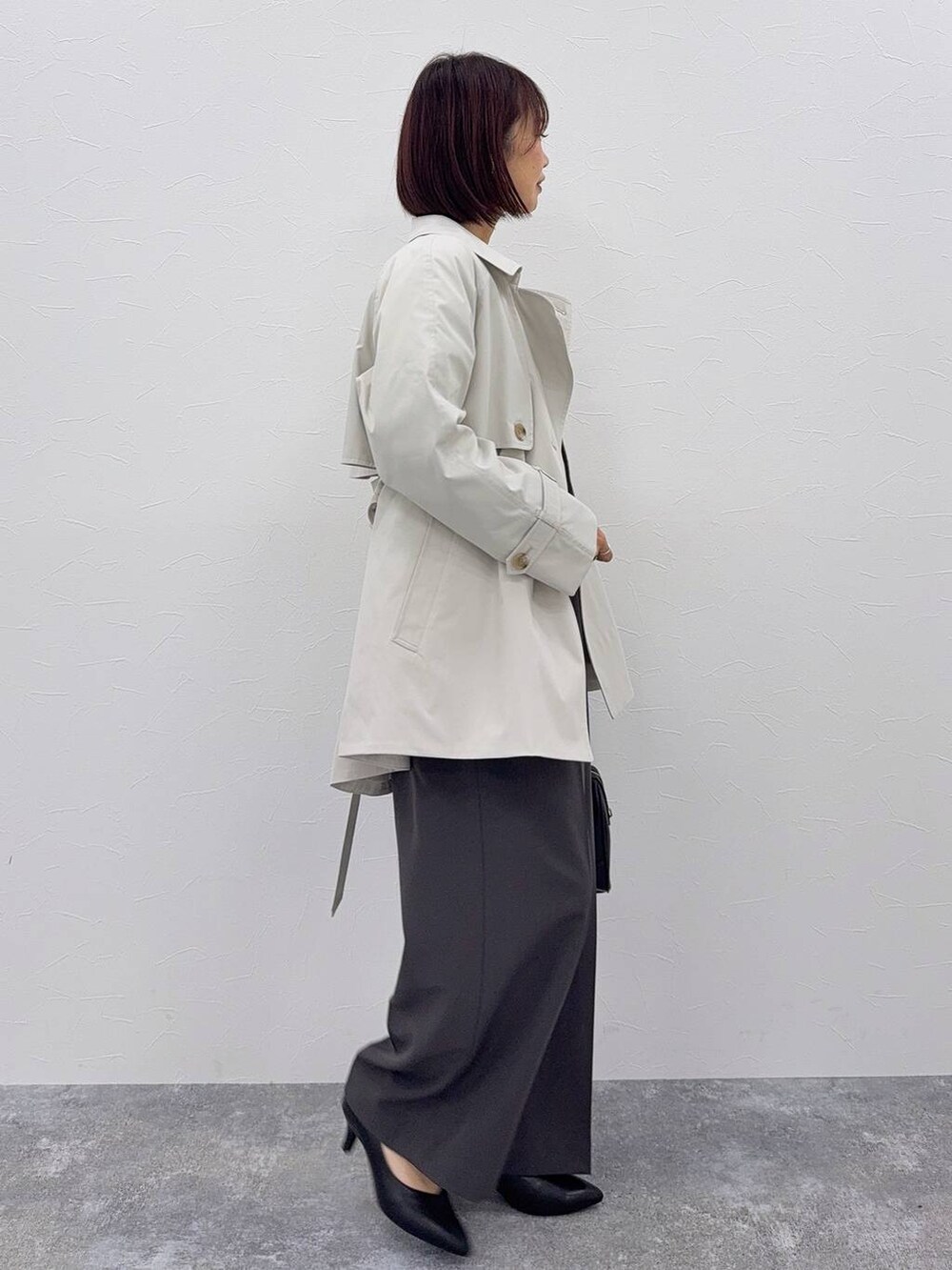 グレー系のセットアップ、ブラック系のボストンバッグ、その他のネックレスを着用したレディースの秋コーディネートの5枚目の写真