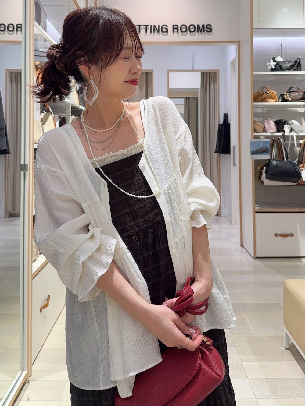 ブラック系のバレエシューズ、レッド系のショルダーバッグ、ブラウン系のワンピースを着用したレディースの春コーディネートの2枚目の写真